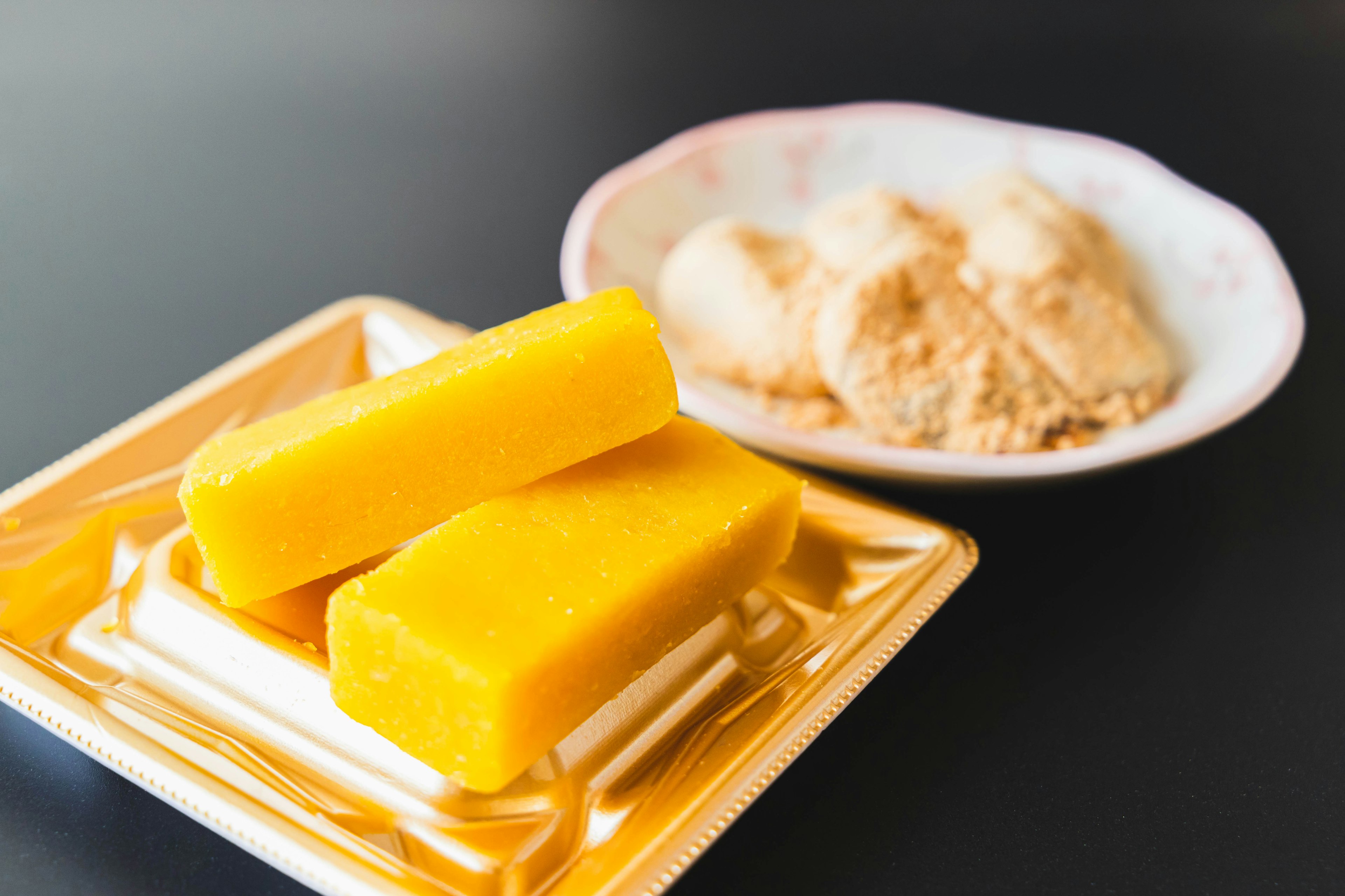 Yellow Japanese sweets and a bowl of soybean flour