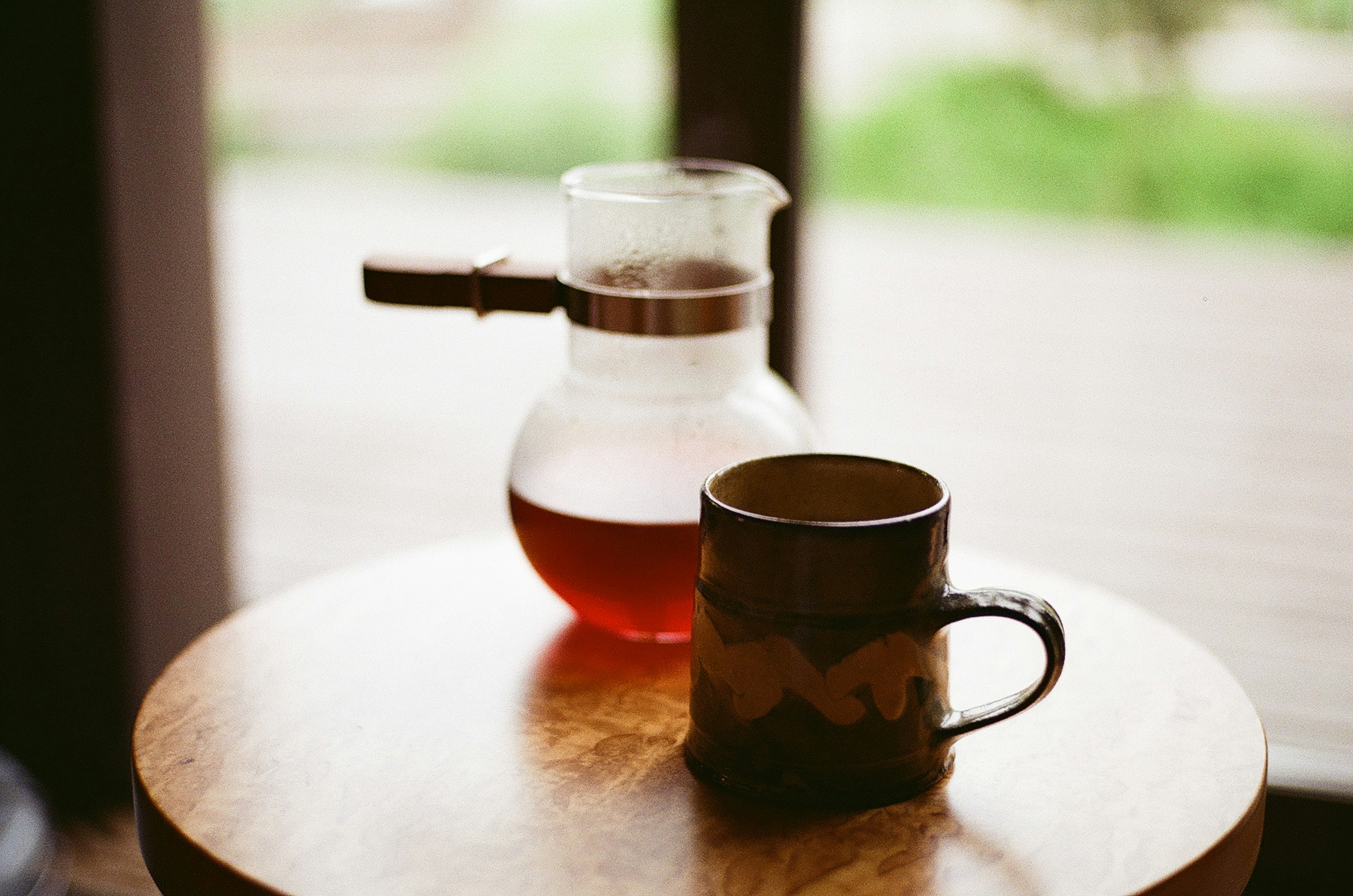 Kaffeekanne und Keramiktasse auf einem Holztisch