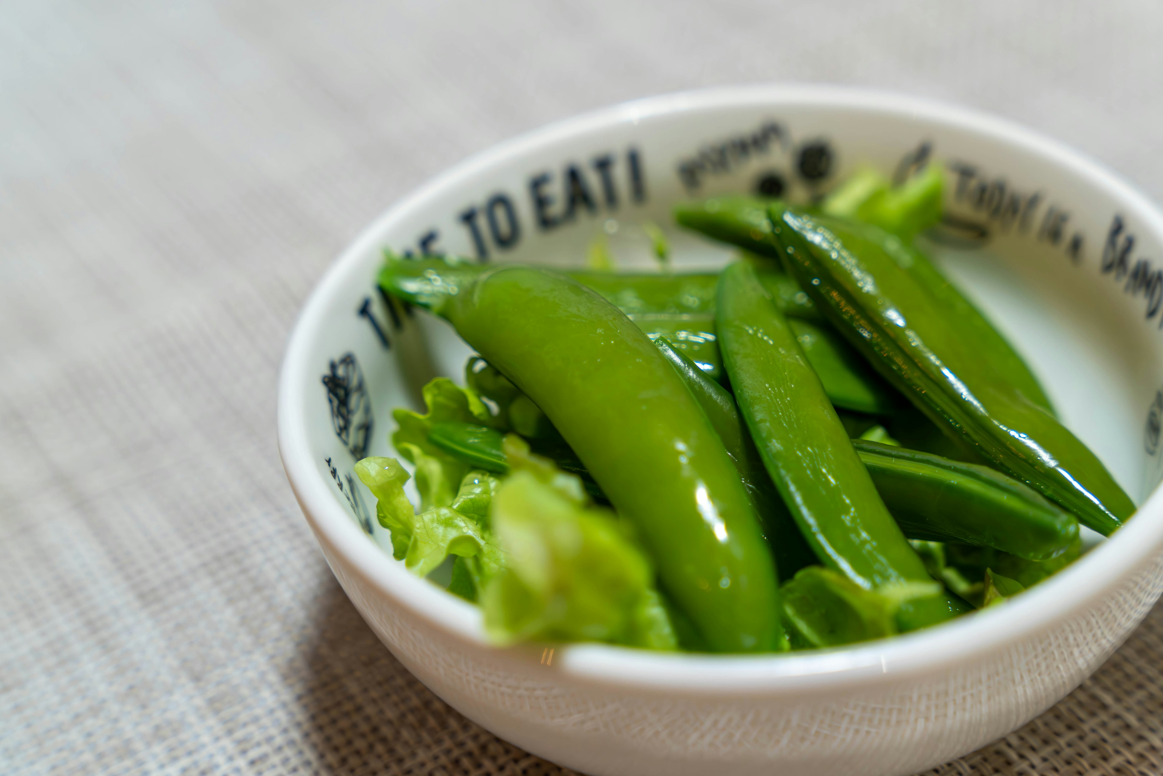 新鮮的綠豌豆和生菜盛在白碗中