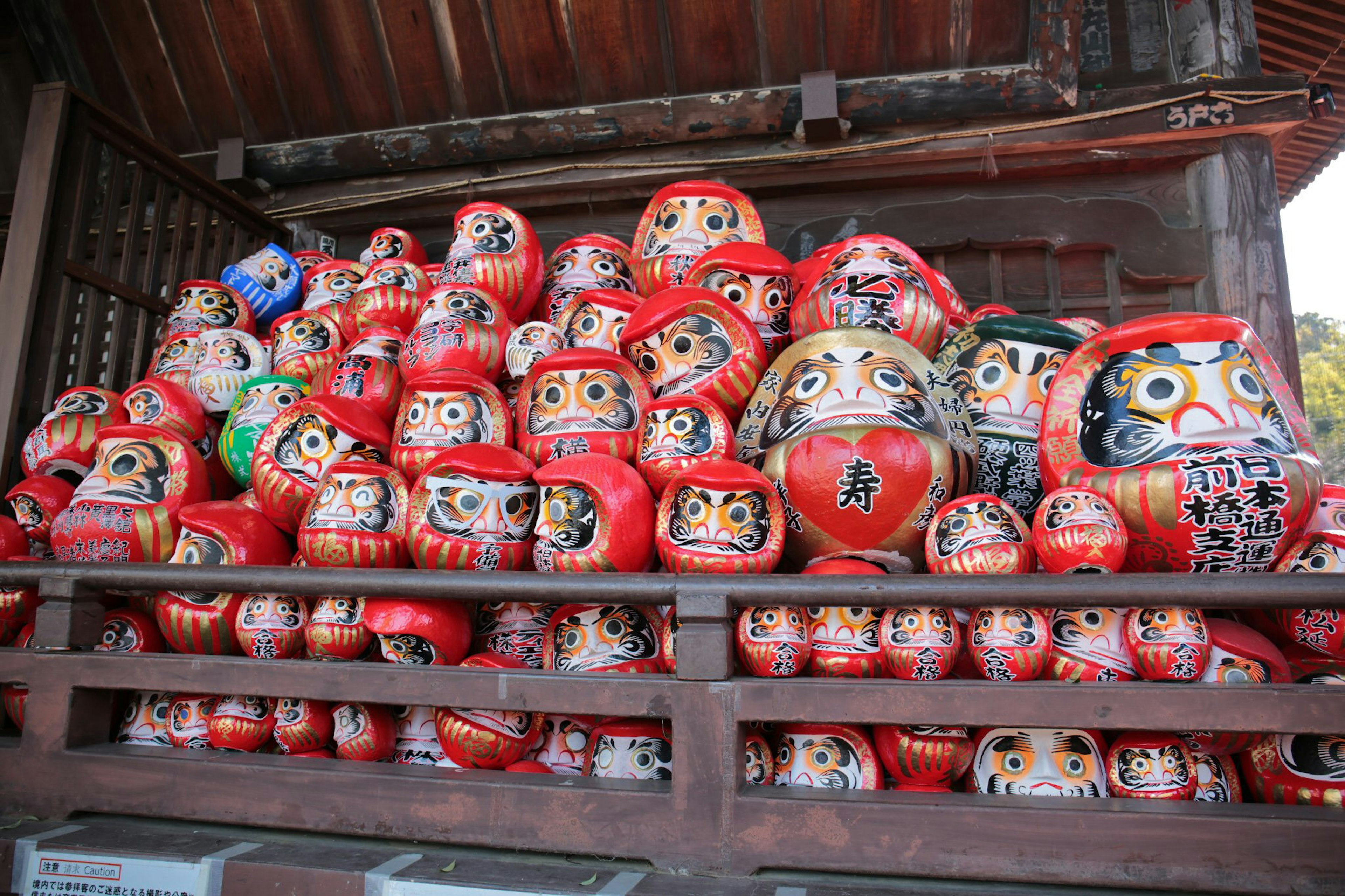 Eine Sammlung roter Daruma-Puppen, die gestapelt sind