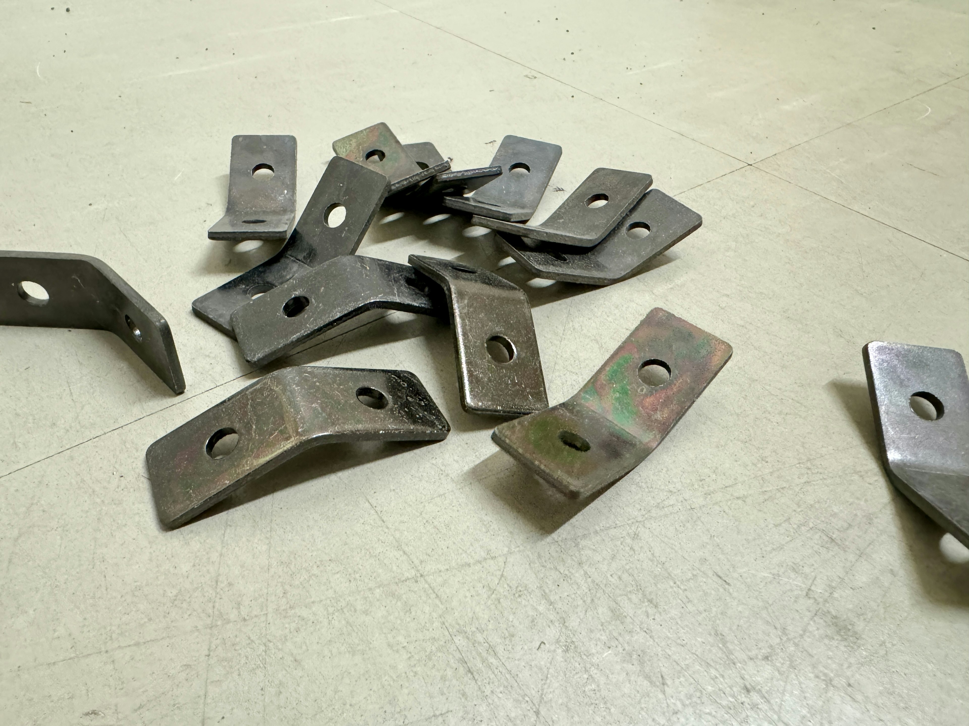 A collection of metal brackets scattered on a surface