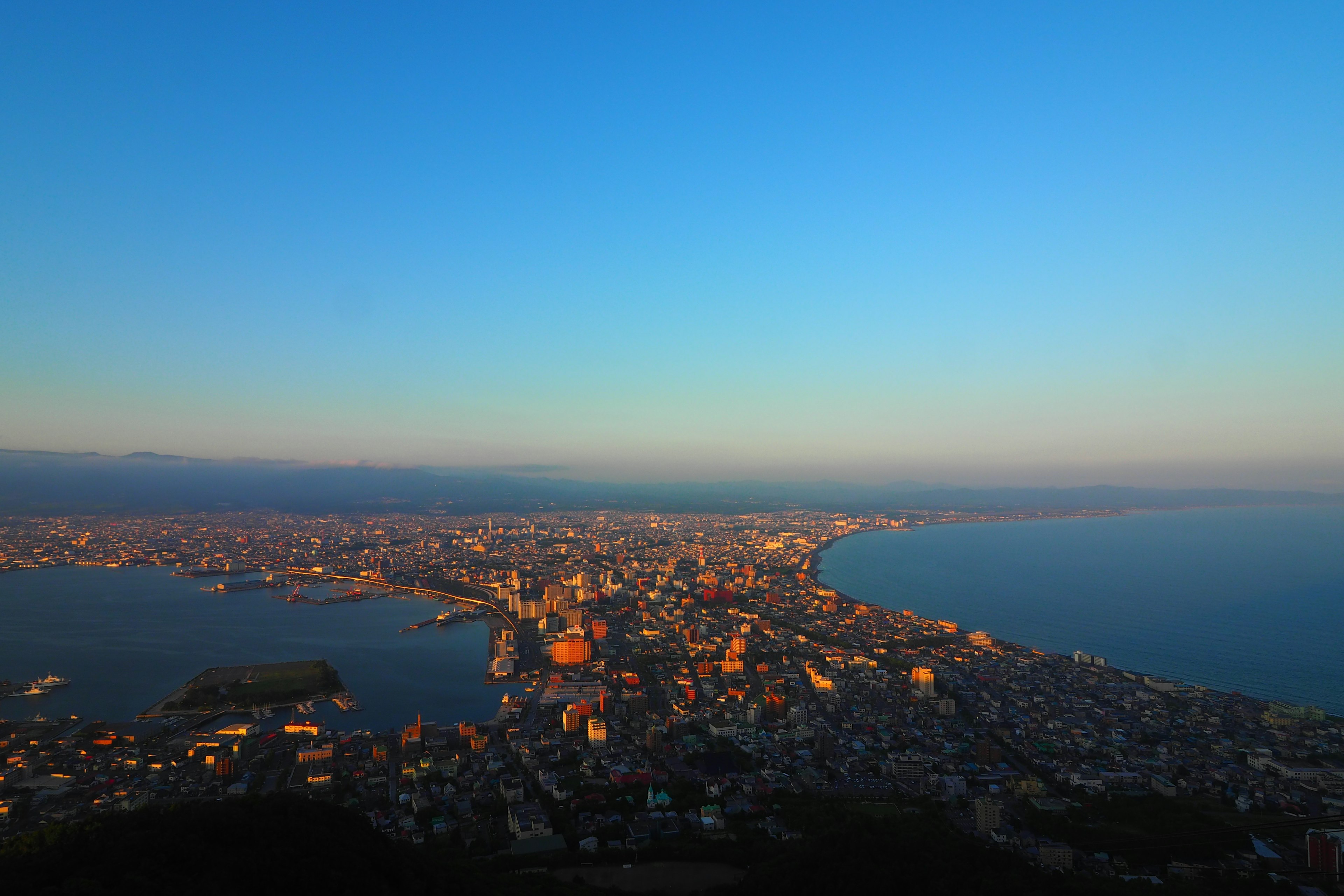 Vue panoramique d'une ville au crépuscule avec la mer et des bâtiments