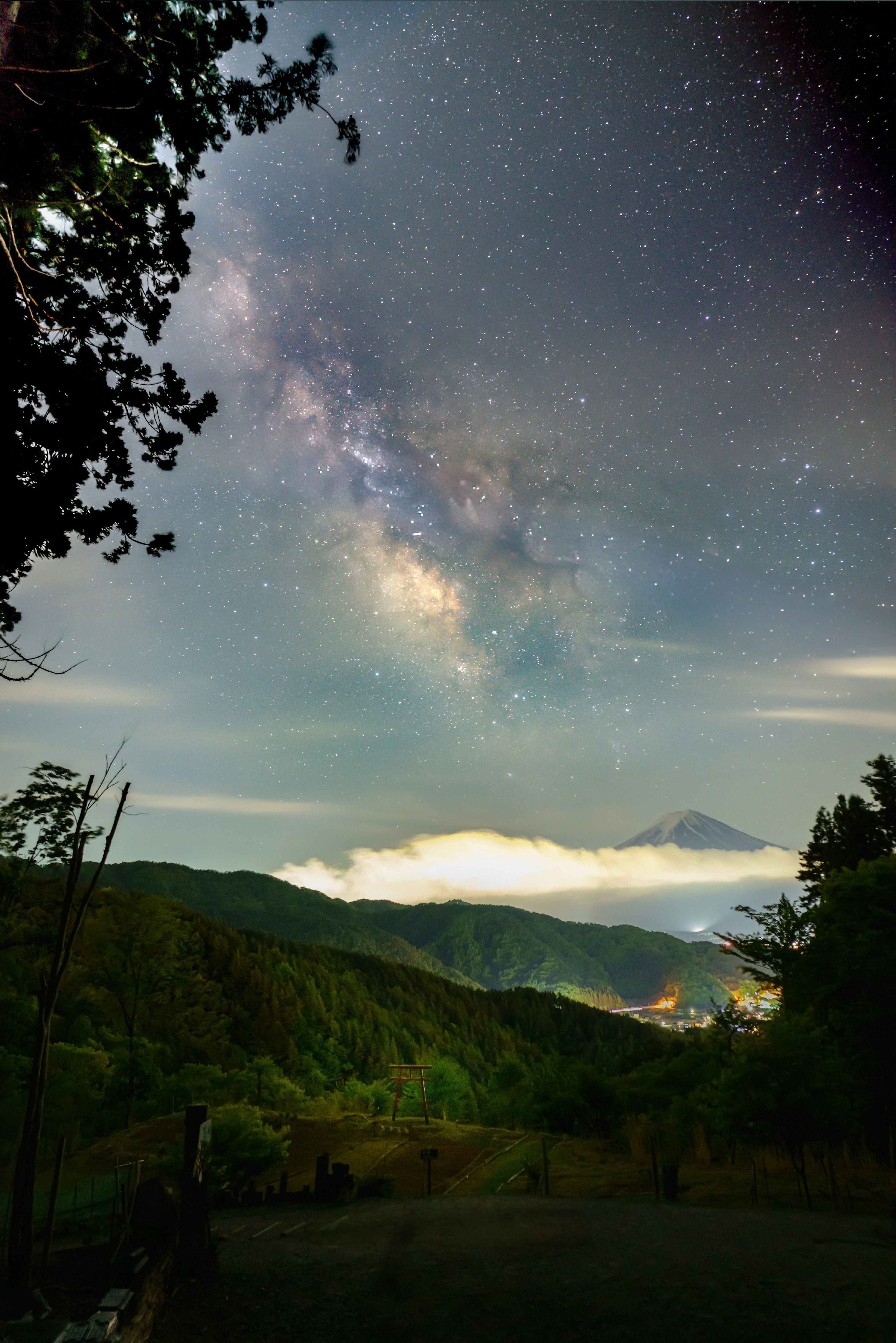 美しい星空の下で富士山が雲に覆われた風景