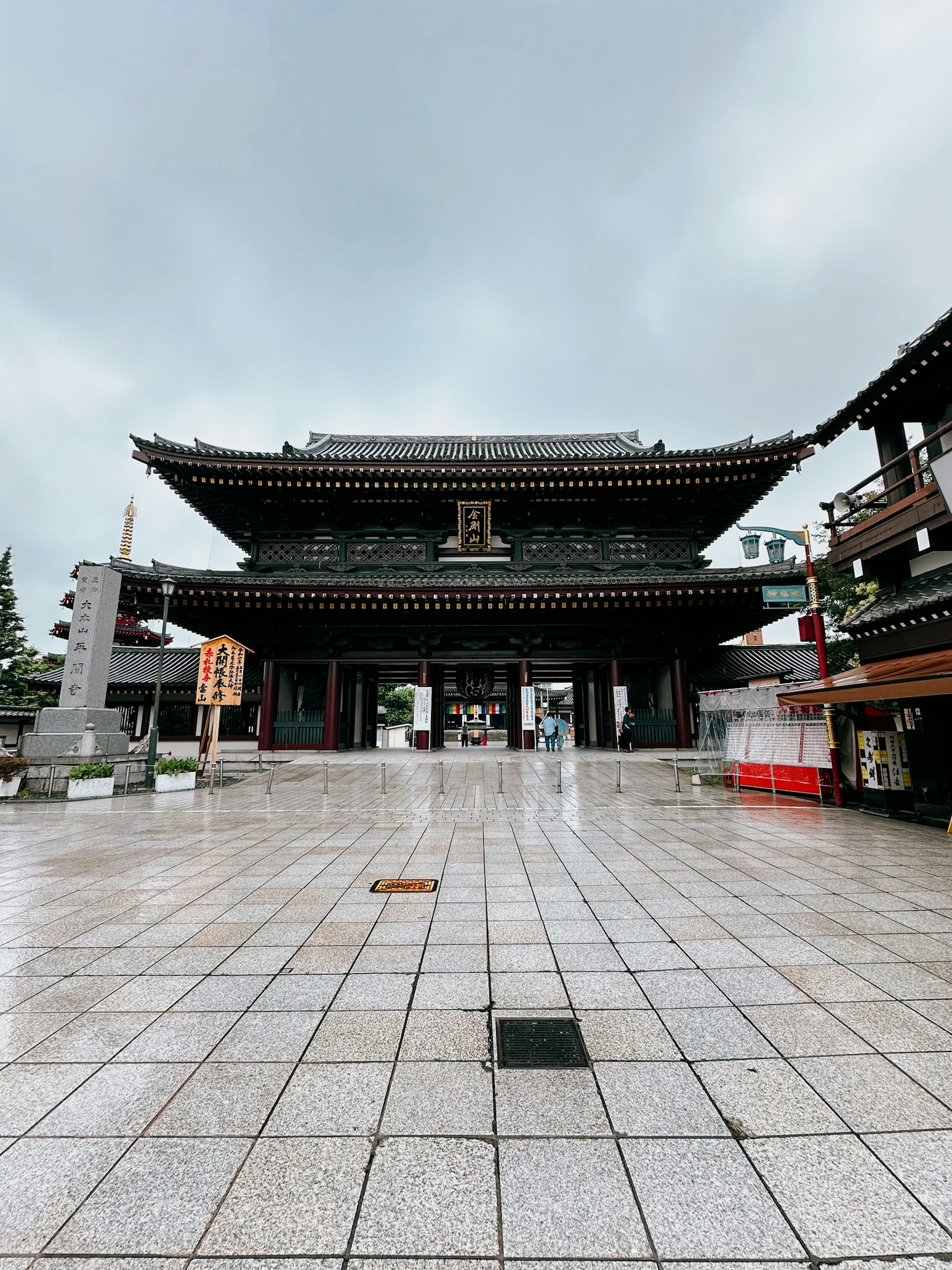 传统日本寺庙大门，湿滑石板路在阴云下