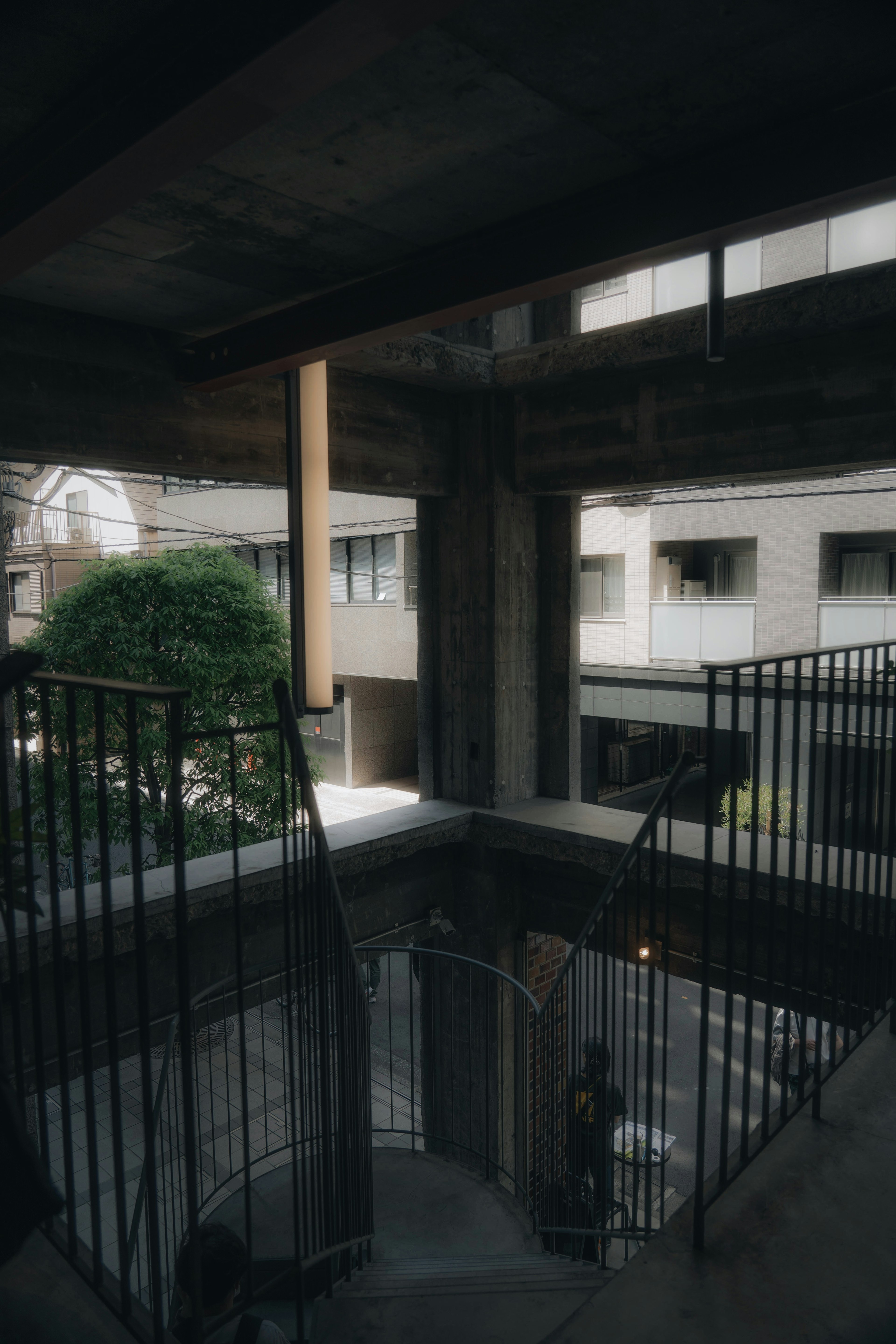 Intérieur d'un bâtiment moderne avec des escaliers en béton et une cour