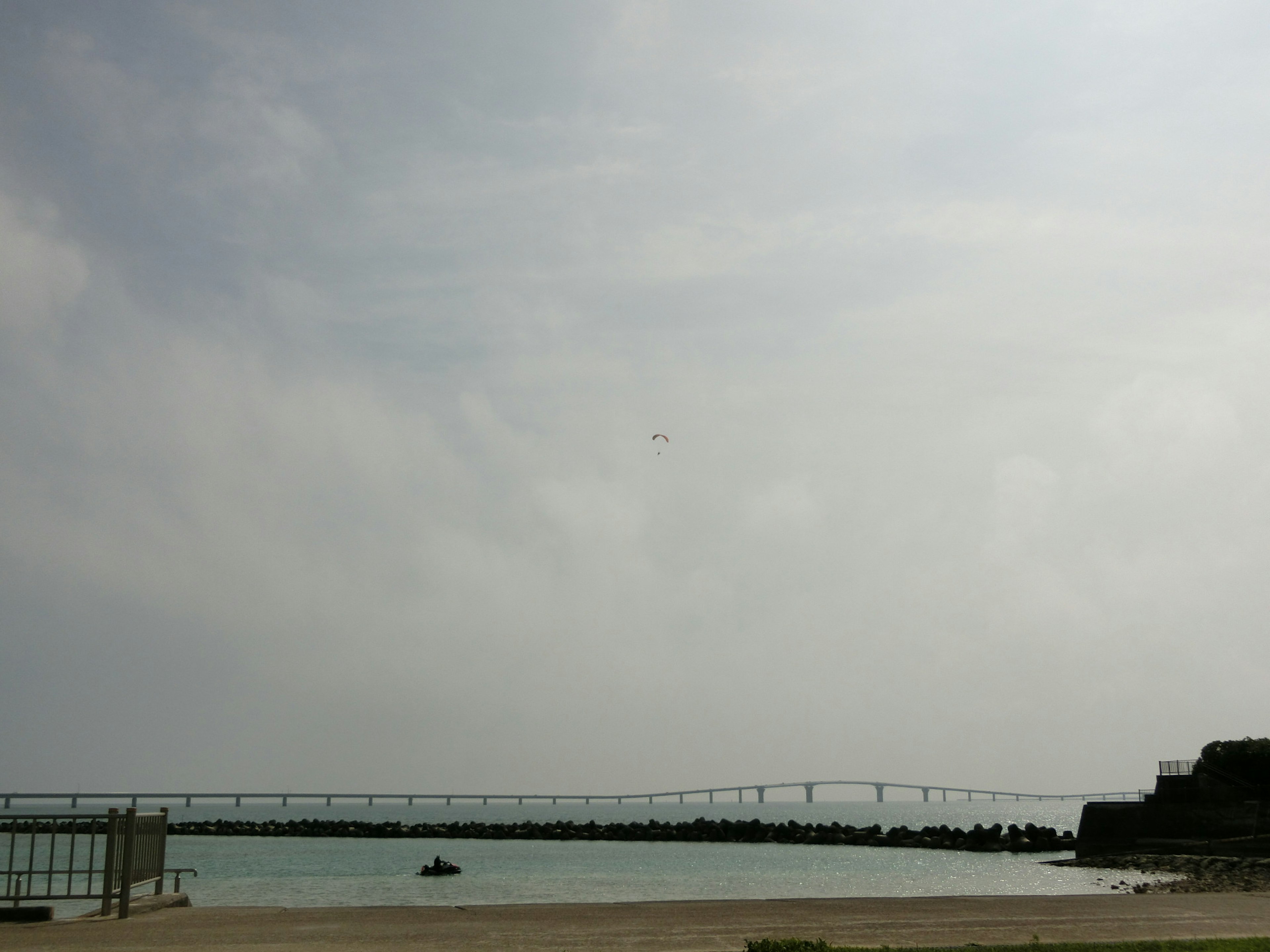 Ruhige Meeresansicht und Brücke unter einem bewölkten Himmel