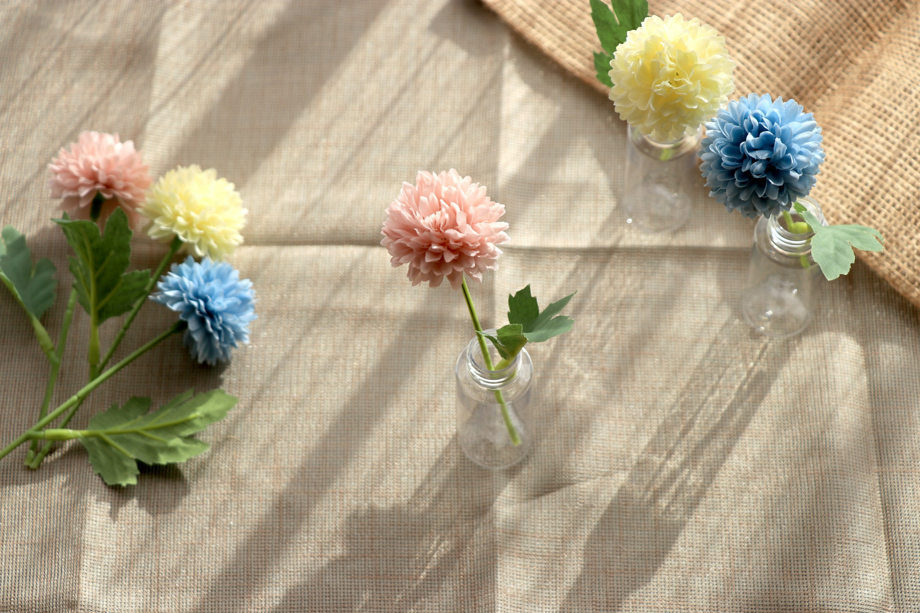 Bunte Blumen in kleinen Vasen auf einem ruhigen Tischarrangement