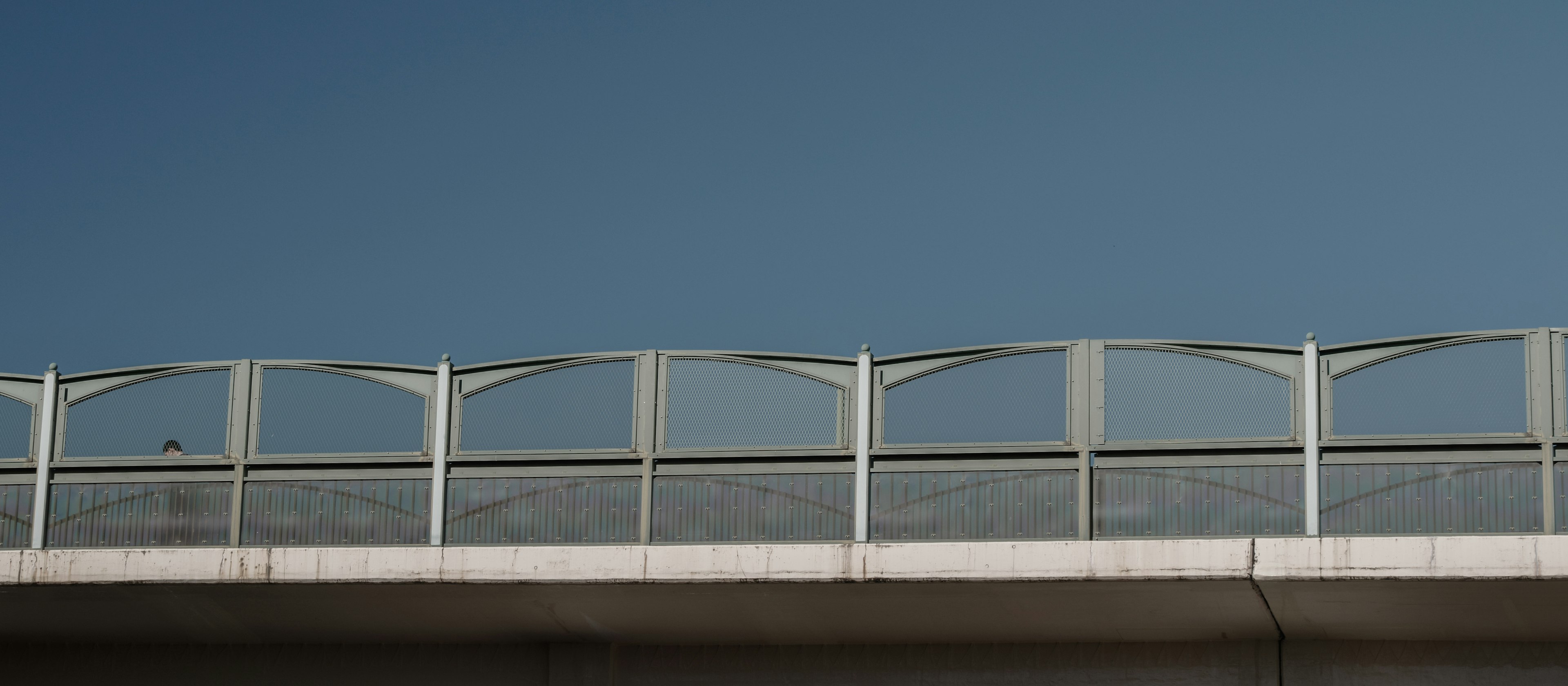 Section d'un pont avec des rampes blanches sous un ciel bleu