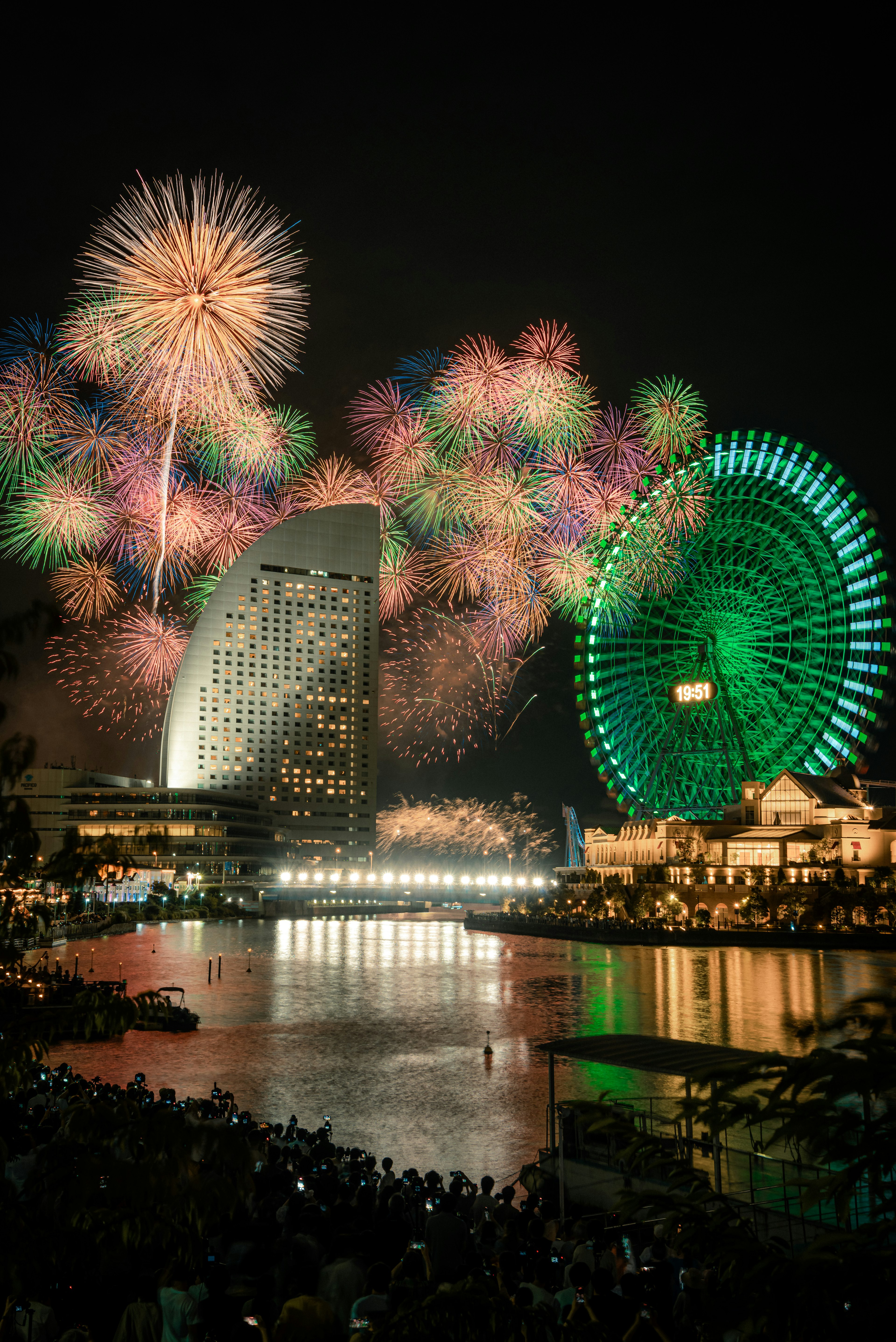 Pháo hoa sáng rực bầu trời đêm với vòng đu quay Yokohama ở phía sau