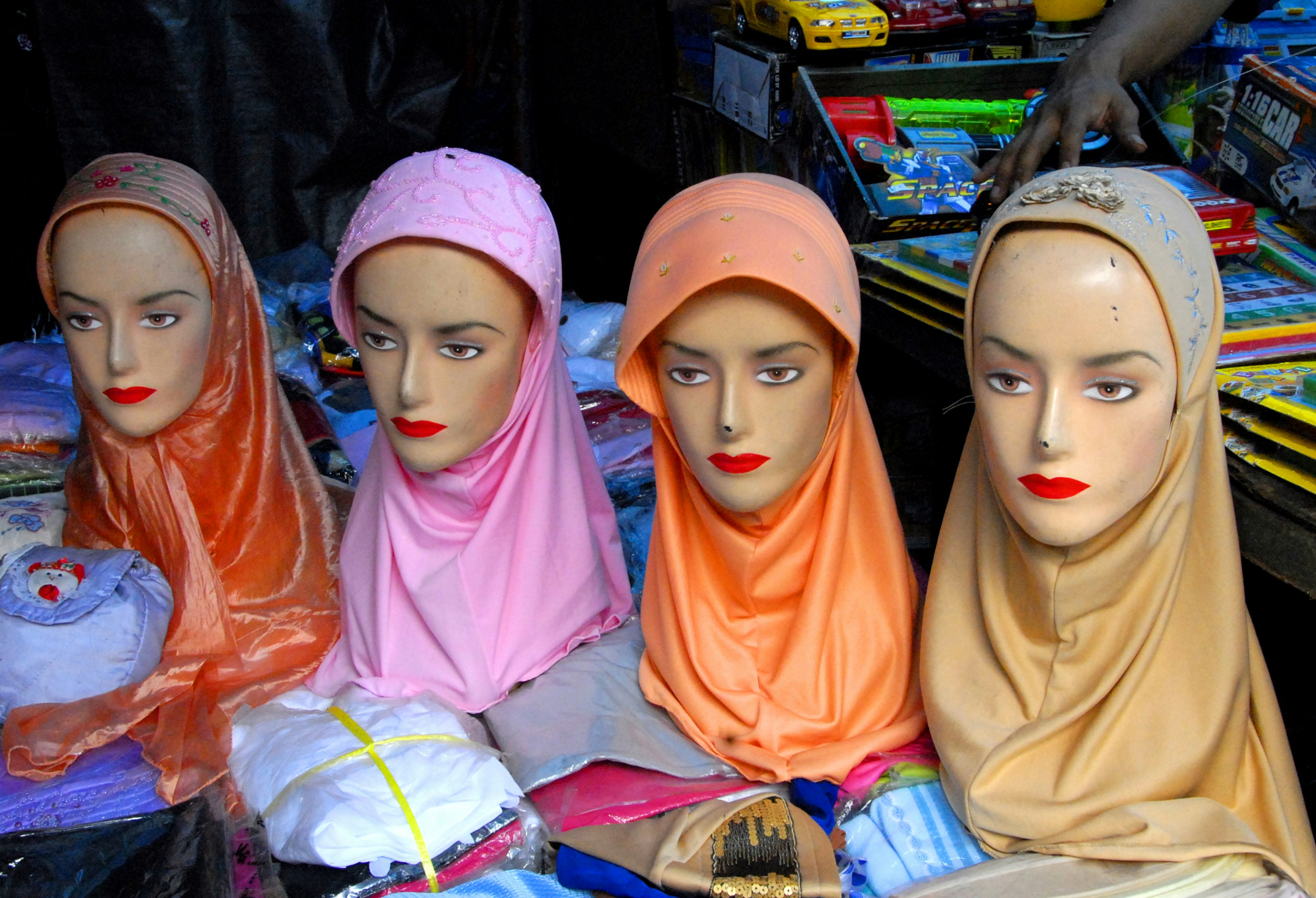 Four mannequins wearing different colored hijabs