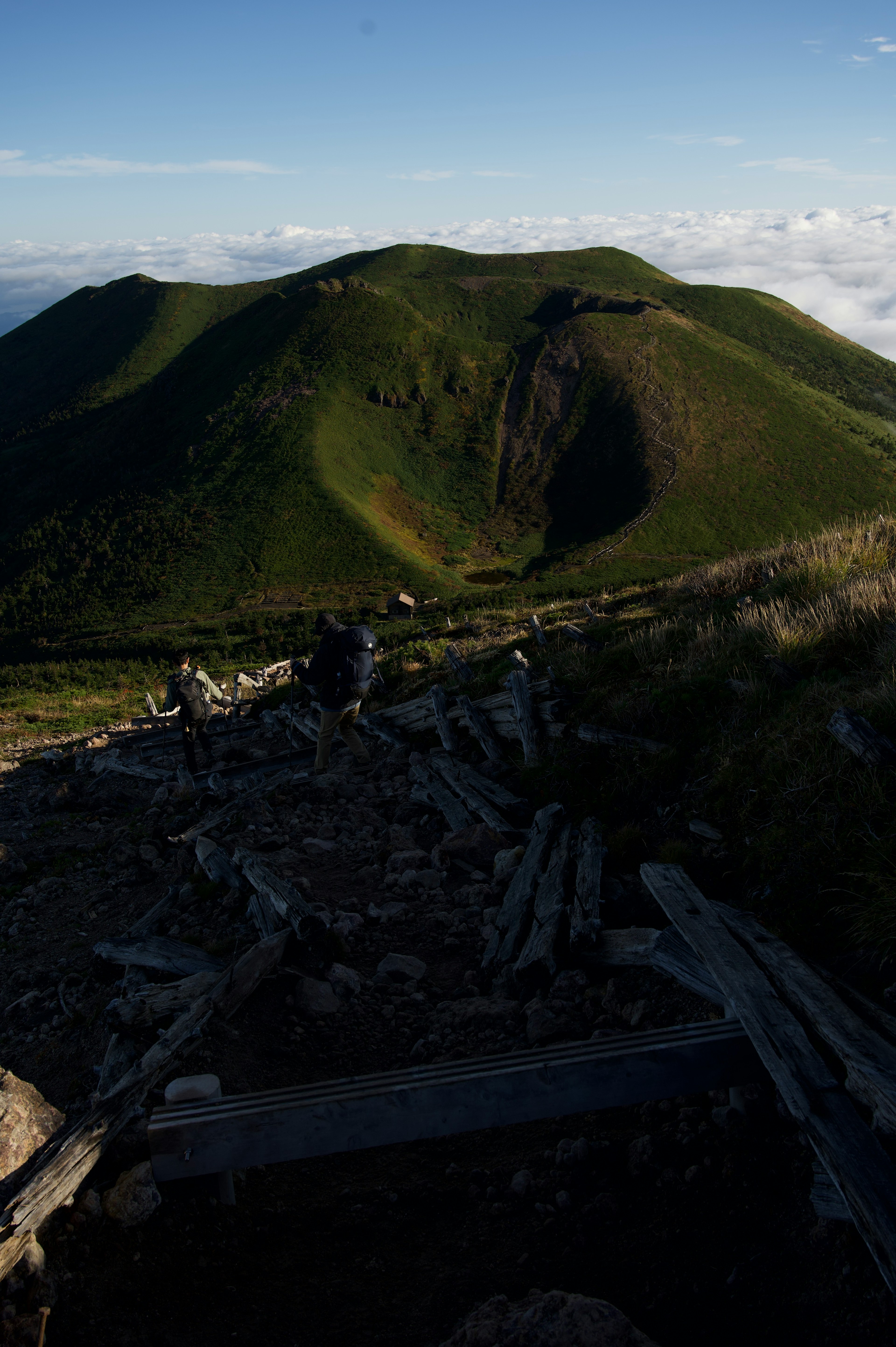 緑の丘と青空の風景で登山者がいる