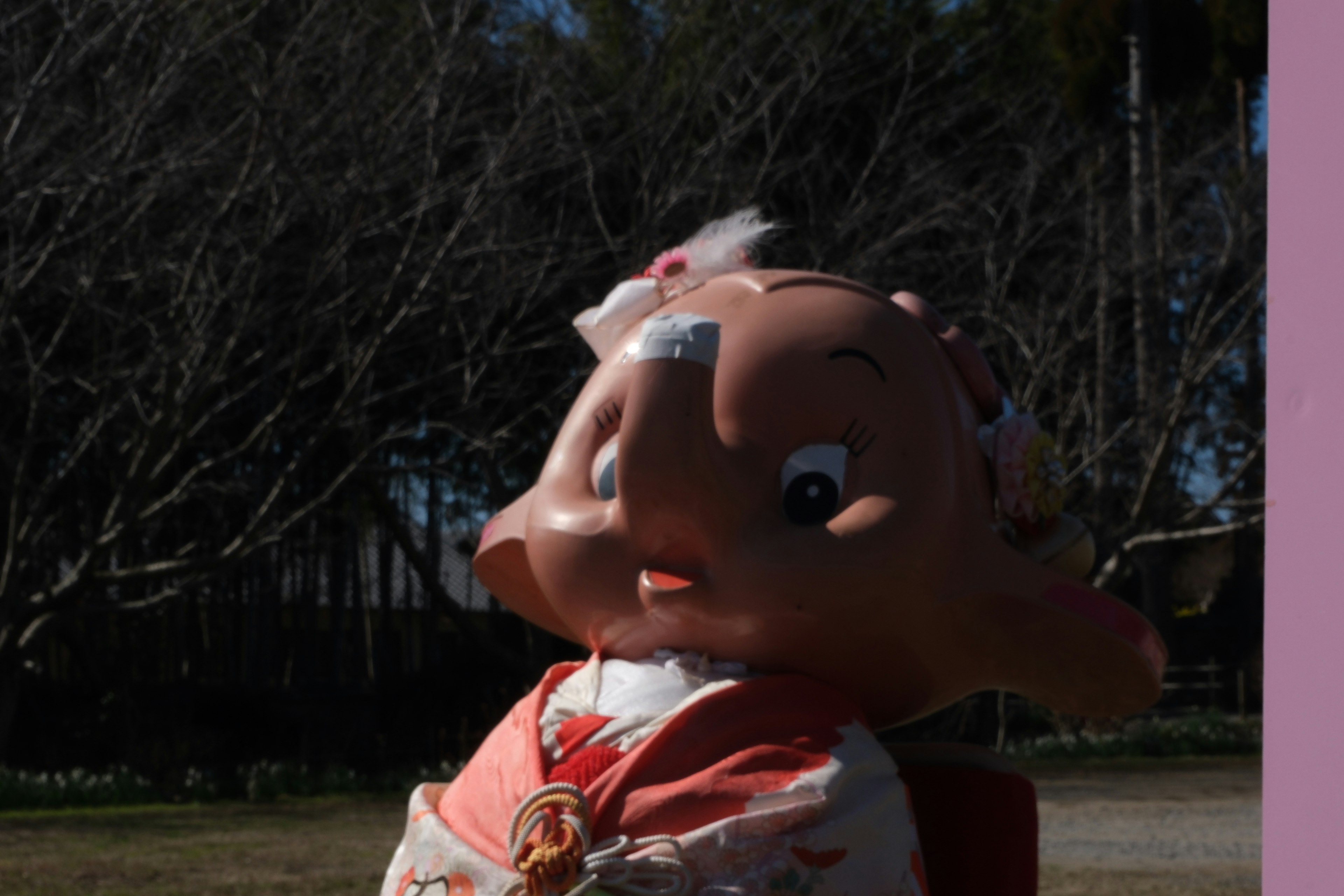 Una estatua de un personaje con un kimono de pie bajo el sol