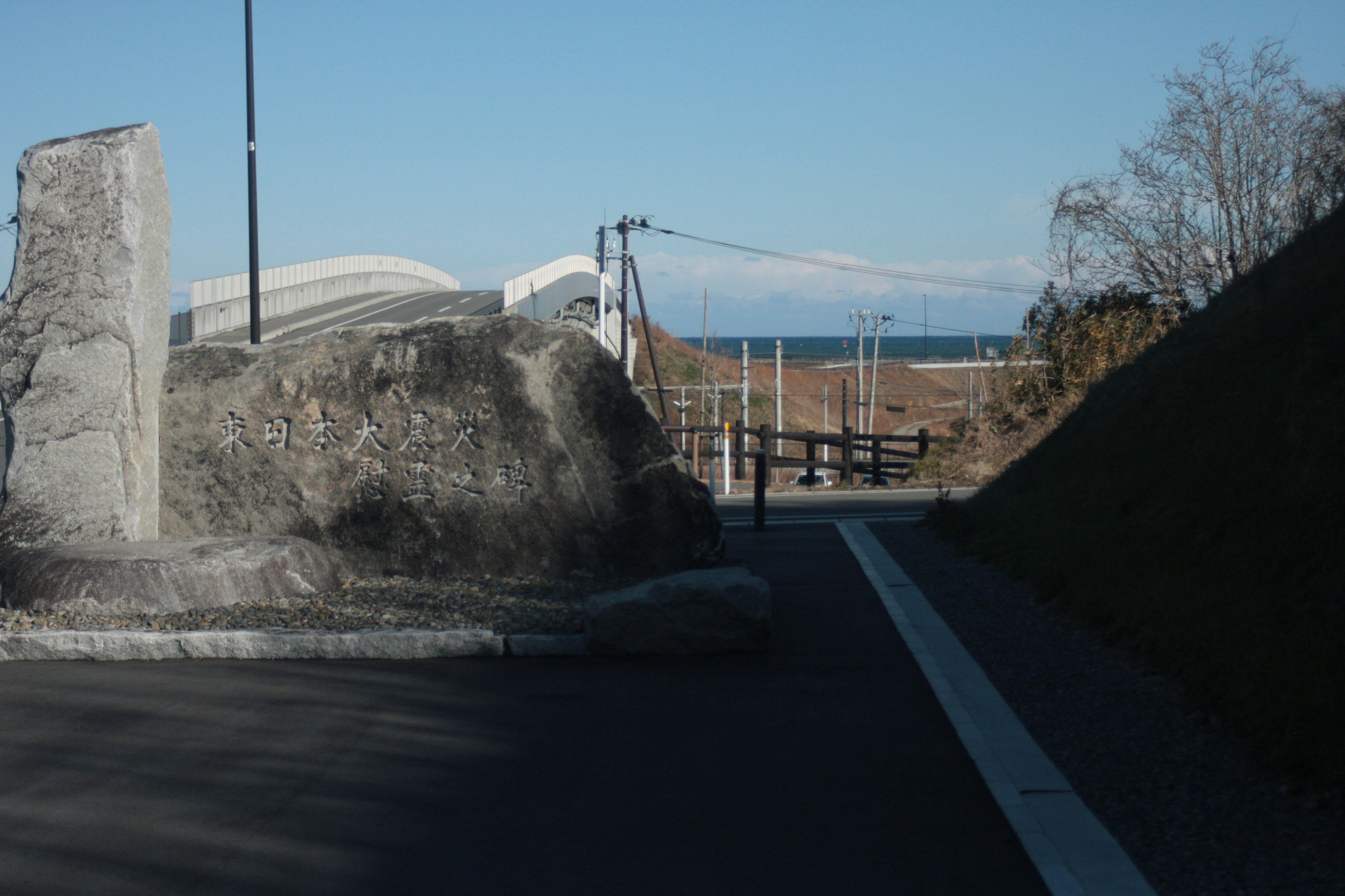 道路の先にある大きな岩と海の景色を背景にした風景