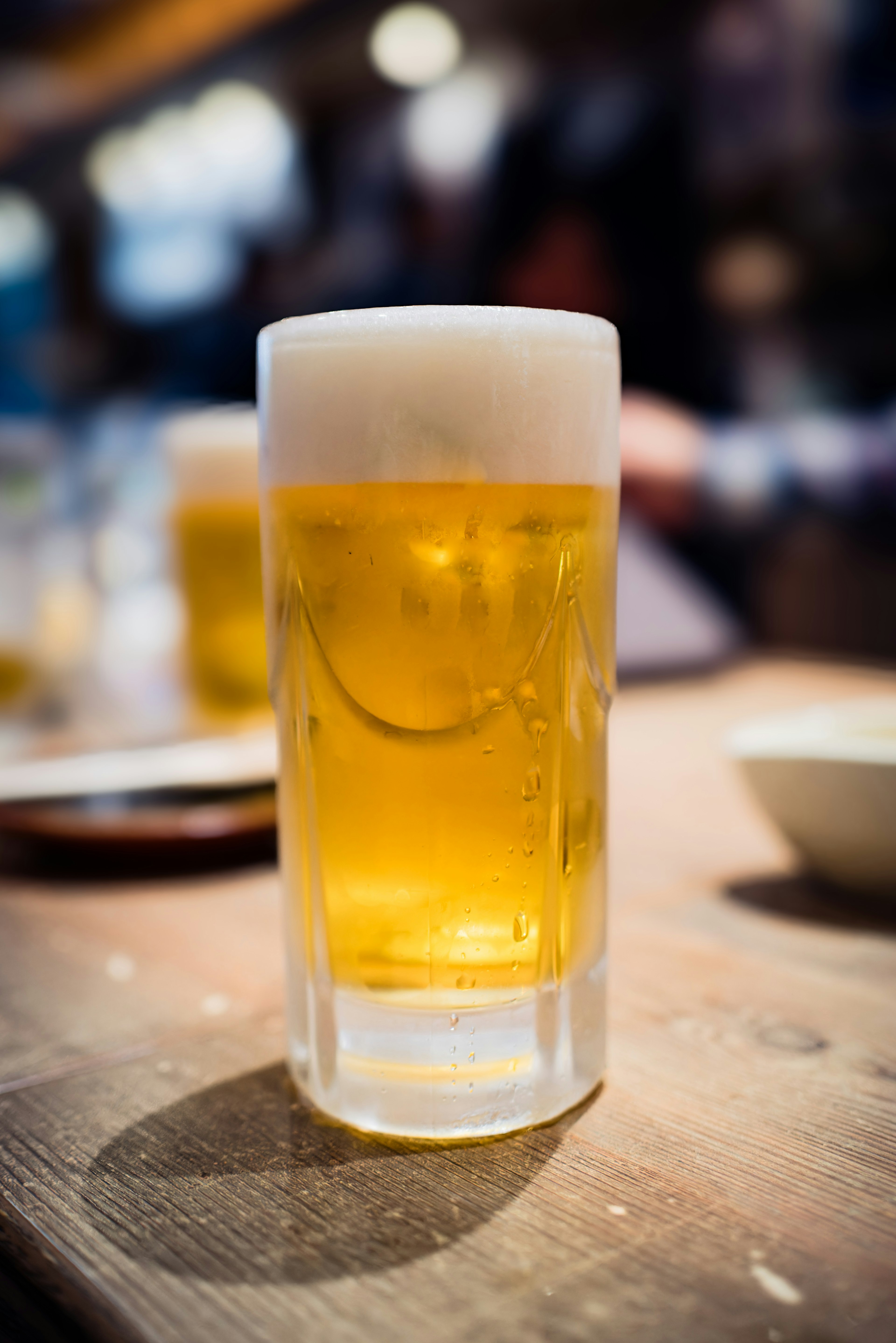 Un vaso de cerveza sobre una mesa de madera