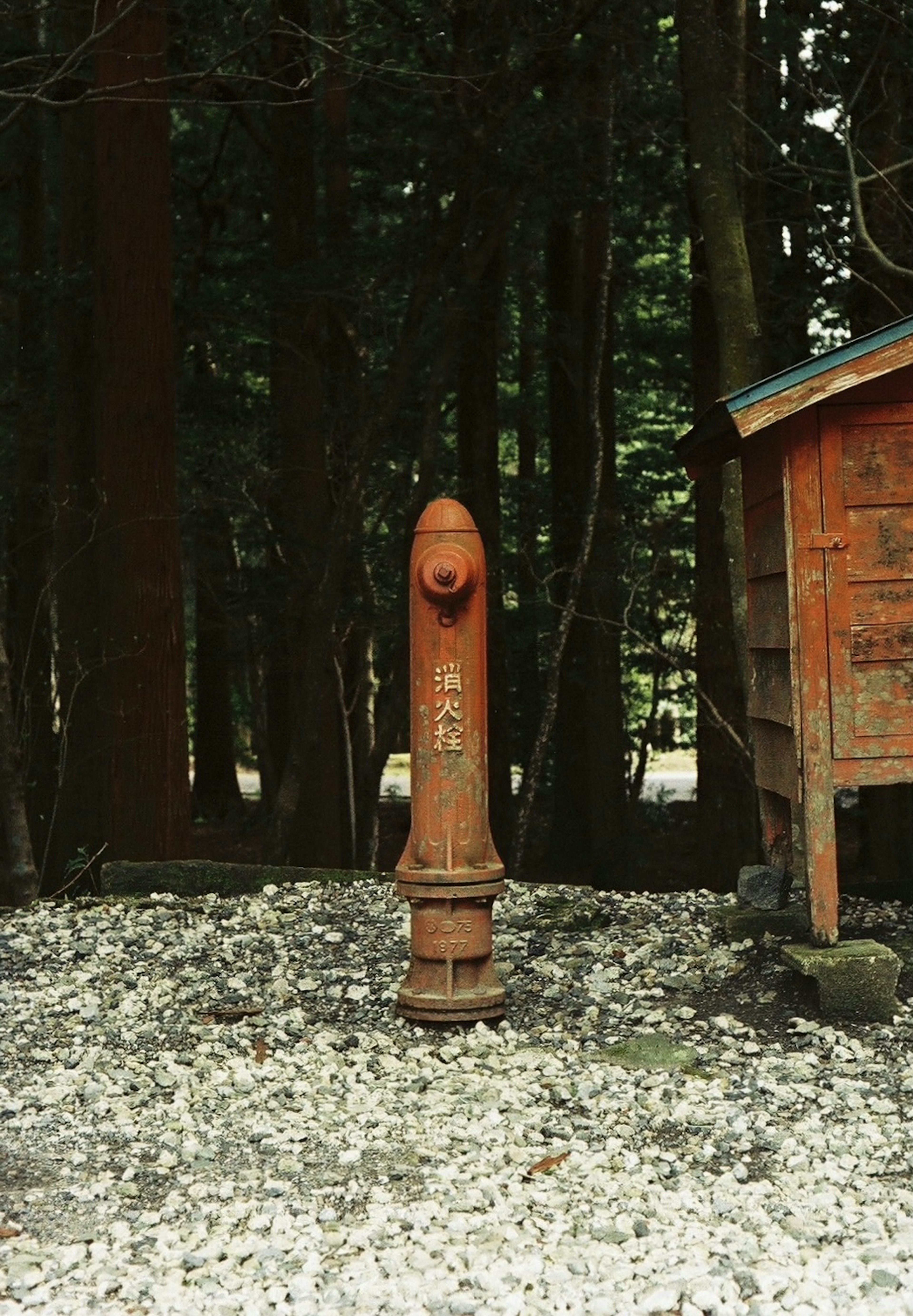 A red stone statue surrounded by trees