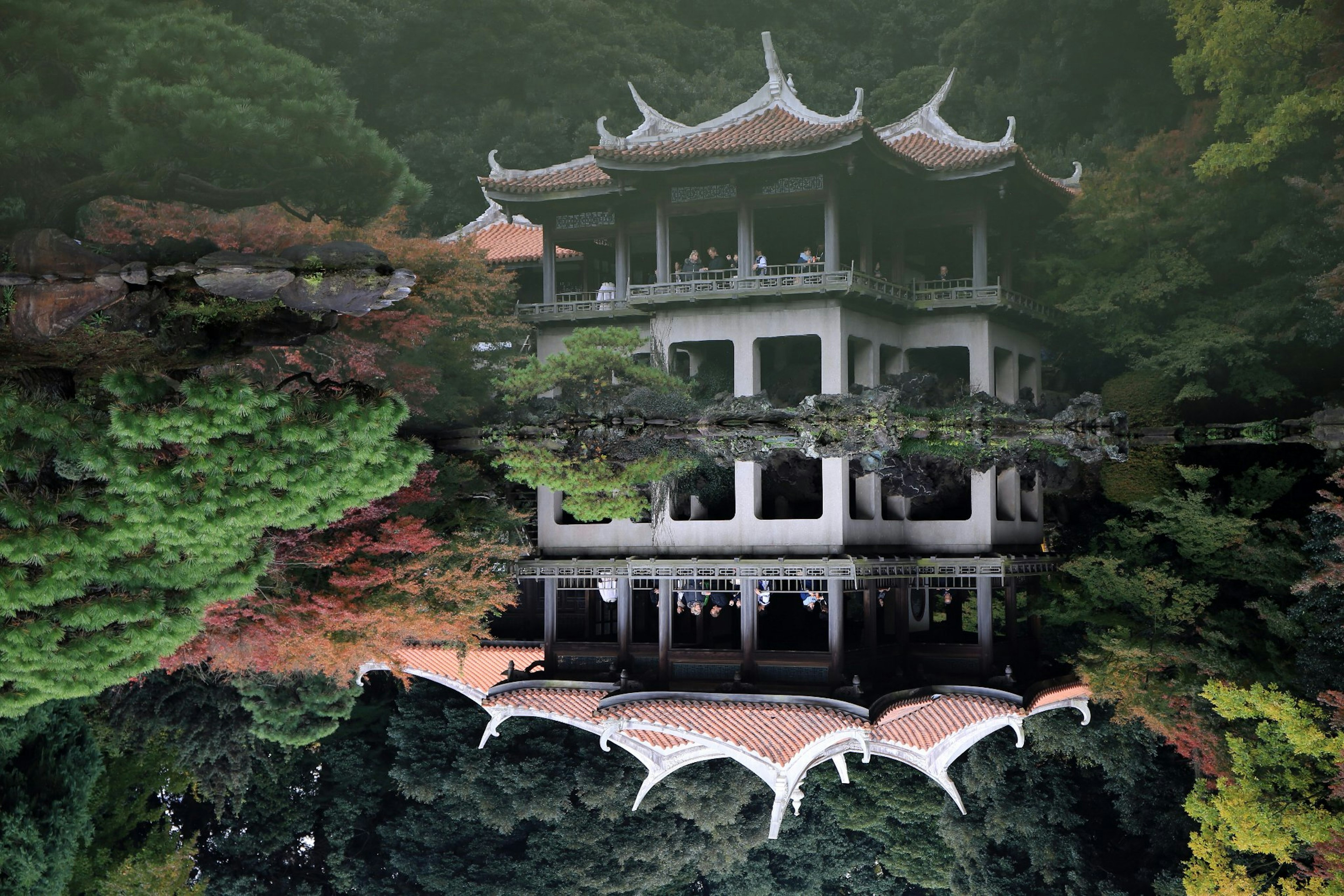 Reflejo de un hermoso edificio tradicional en un estanque rodeado de árboles verdes