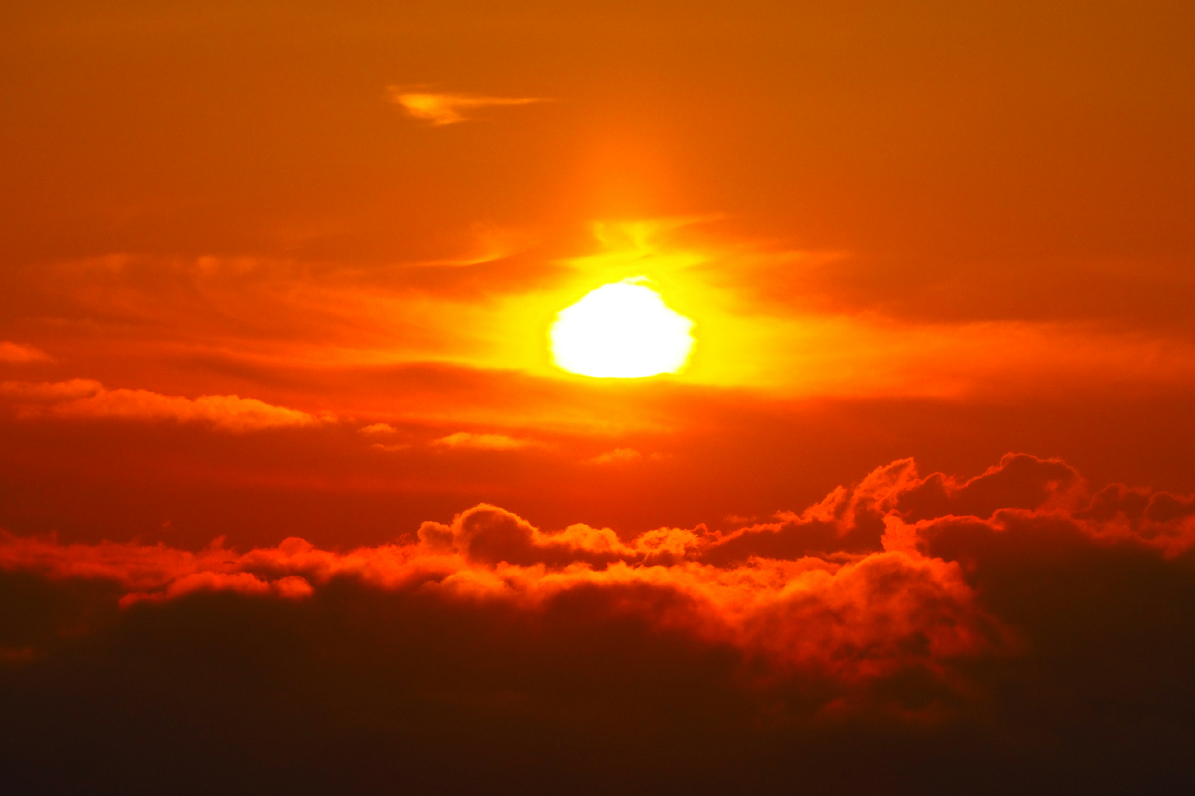 Ein schöner orangefarbener Sonnenuntergang, der durch die Wolken scheint