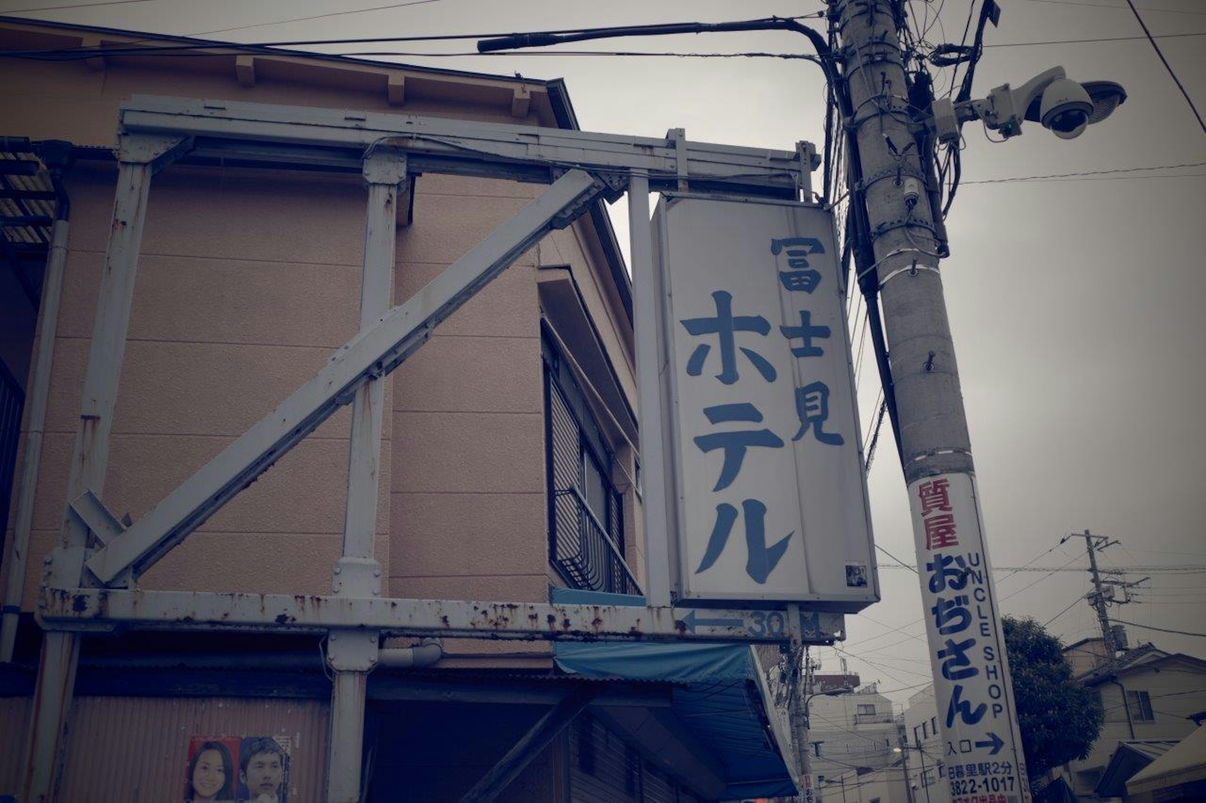 Vue extérieure d'un ancien bâtiment avec le panneau de l'Hôtel Fujimi