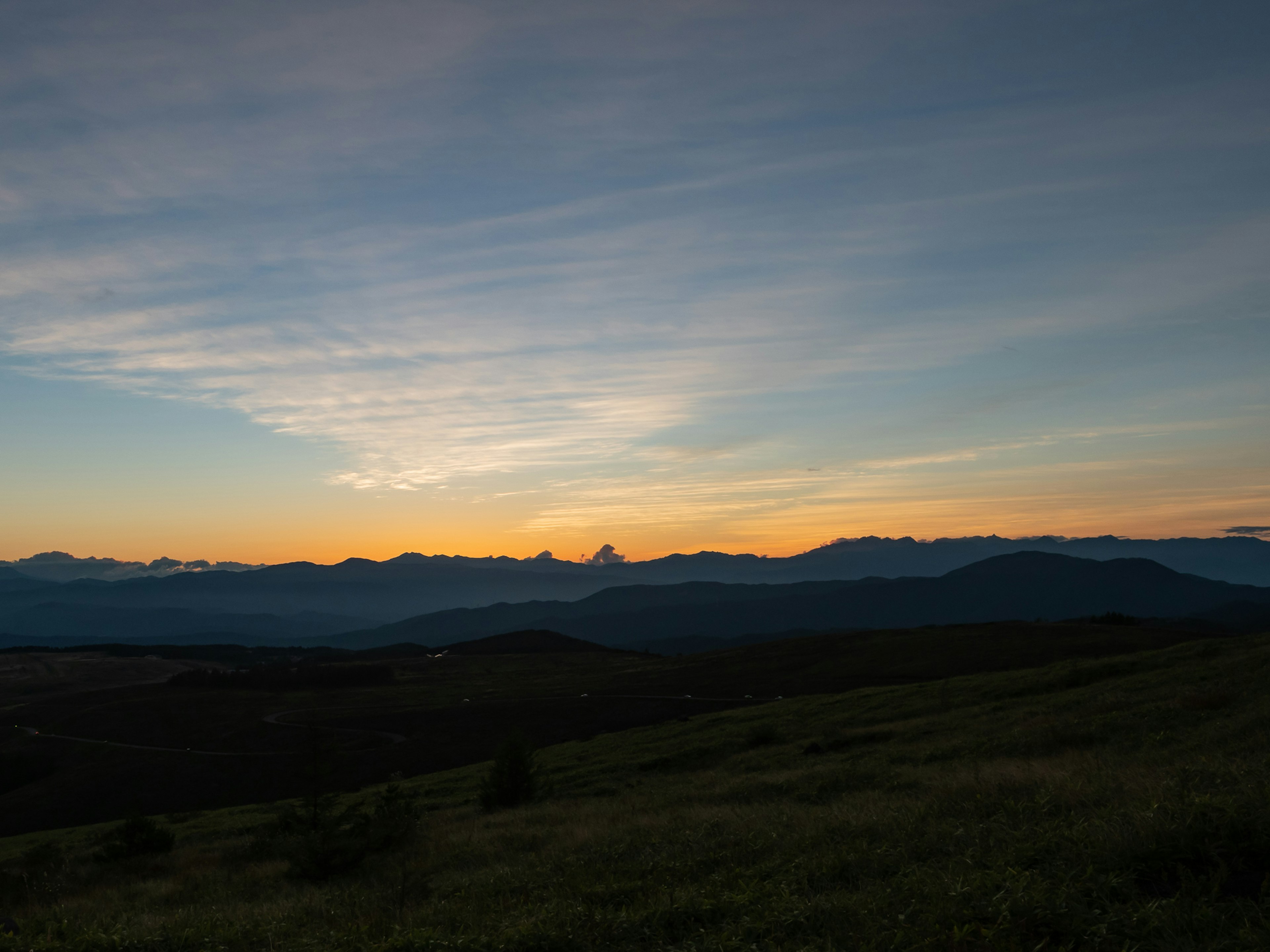 夕焼けの美しい山々の風景と青い空