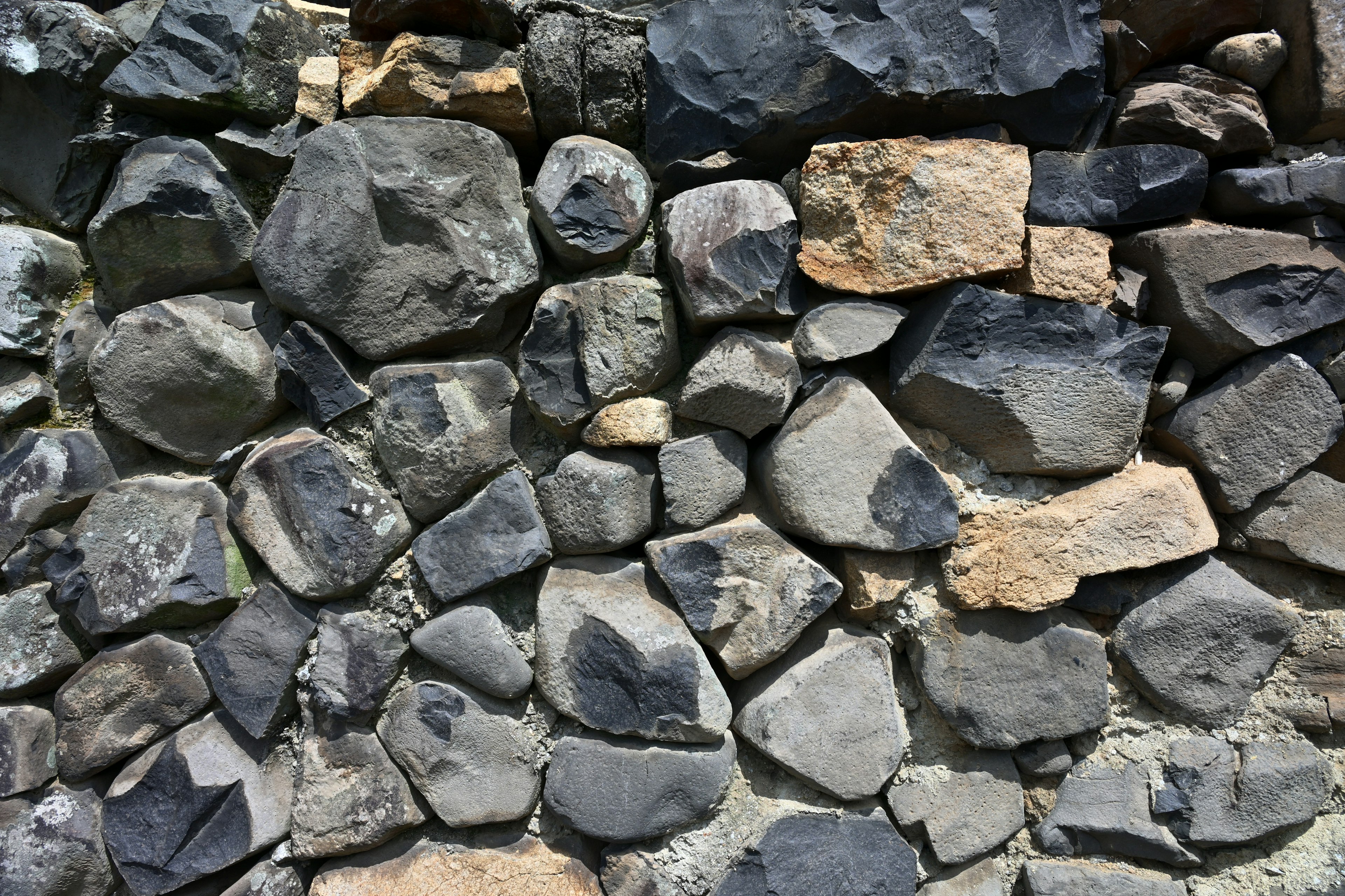 Texture of a wall made of various shapes and colors of stones