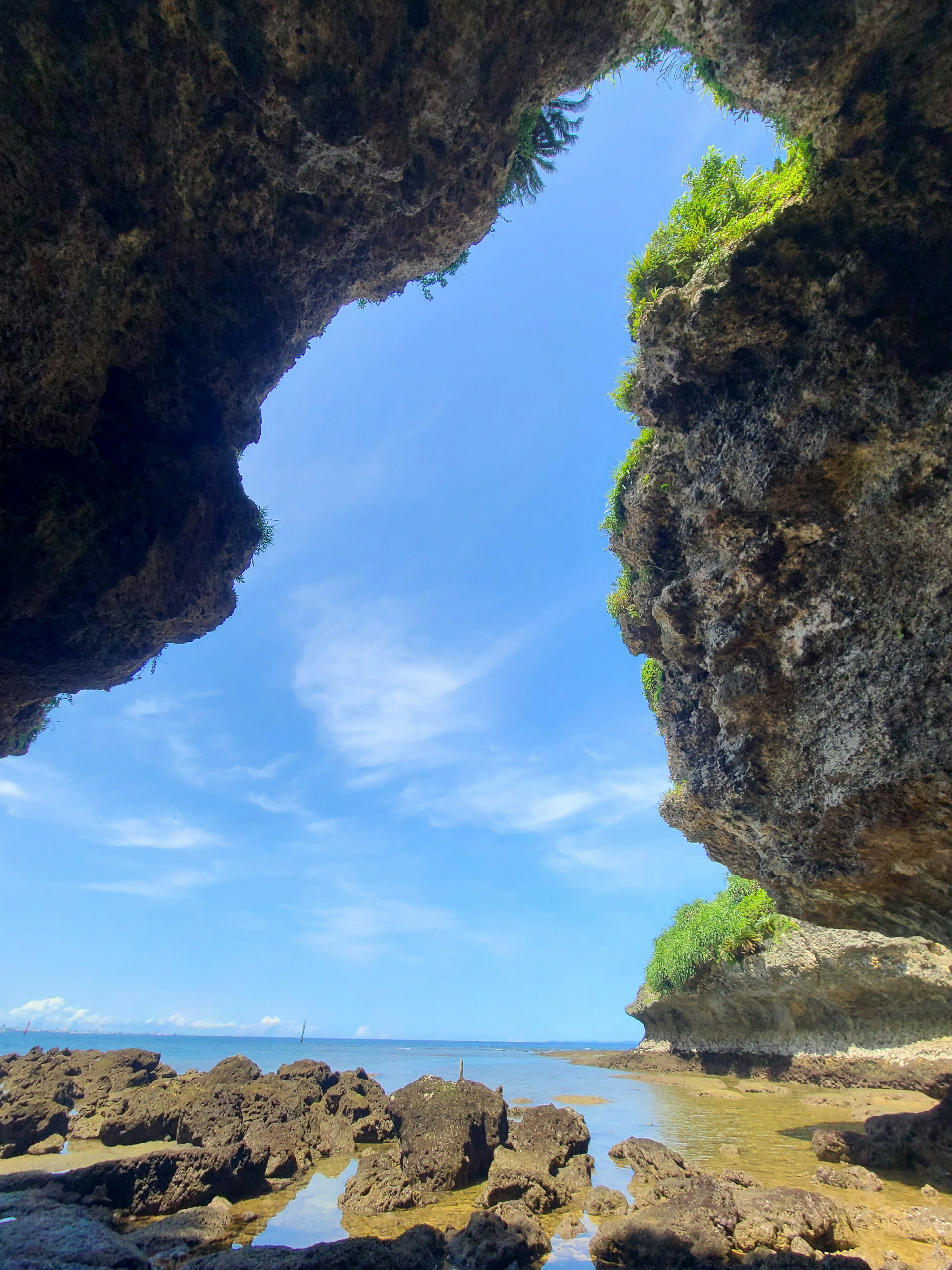 Vue du ciel bleu et de la mer à travers une arche rocheuse