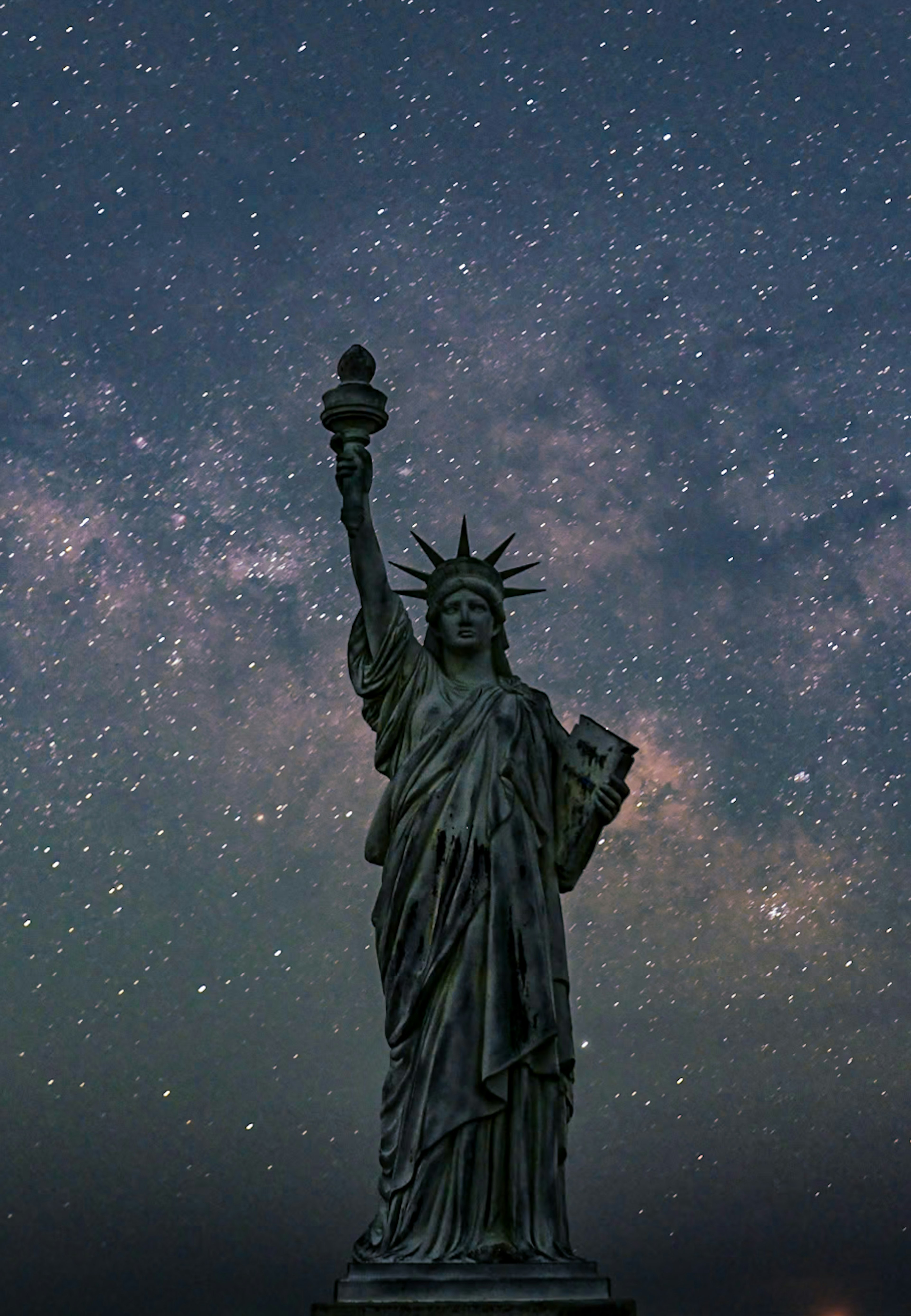 夜空に輝く星々を背景に立つ自由の女神像