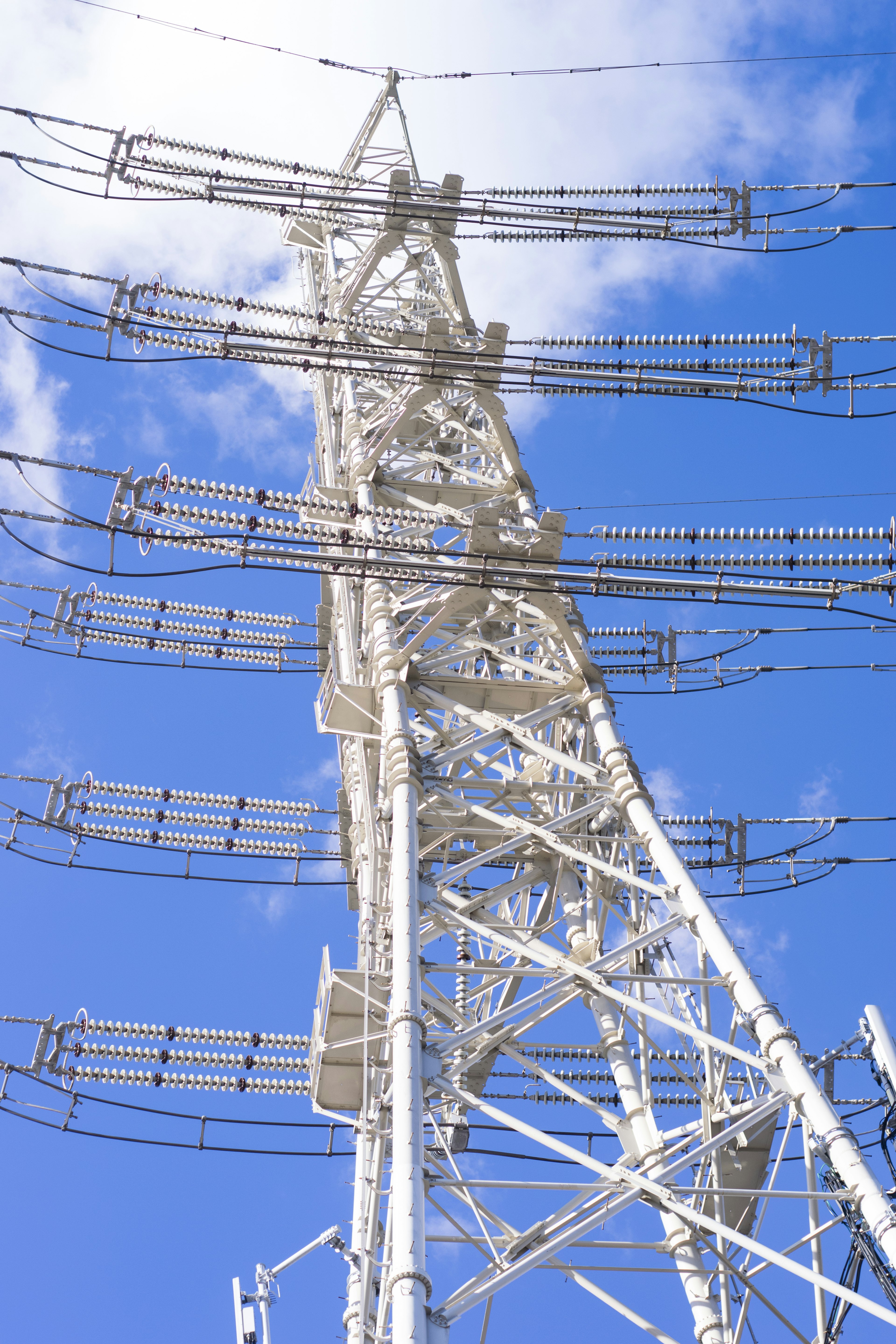 Dettaglio di una torre di comunicazione bianca contro un cielo blu