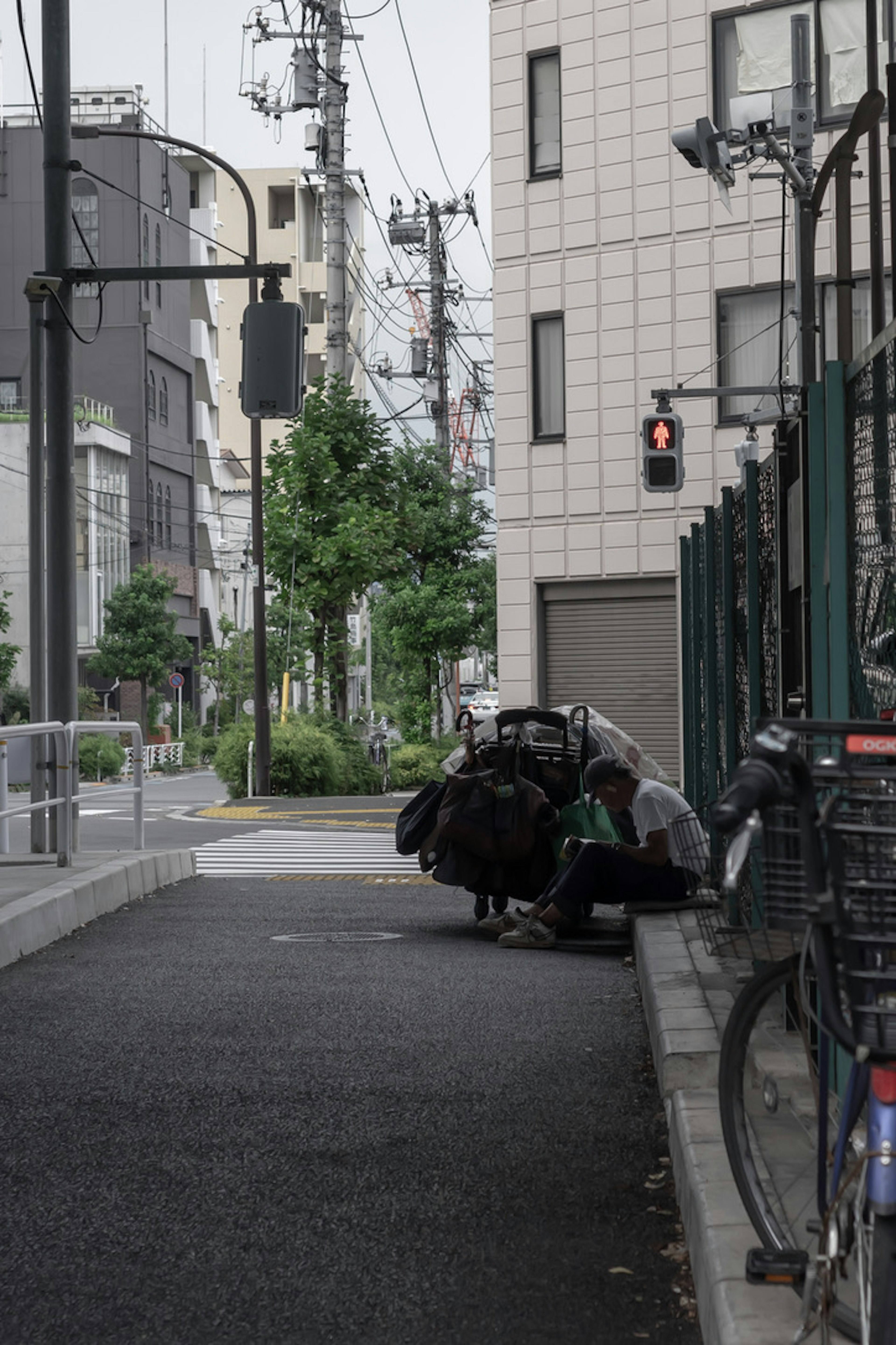 街角の狭い通りに座る人と自転車がある風景