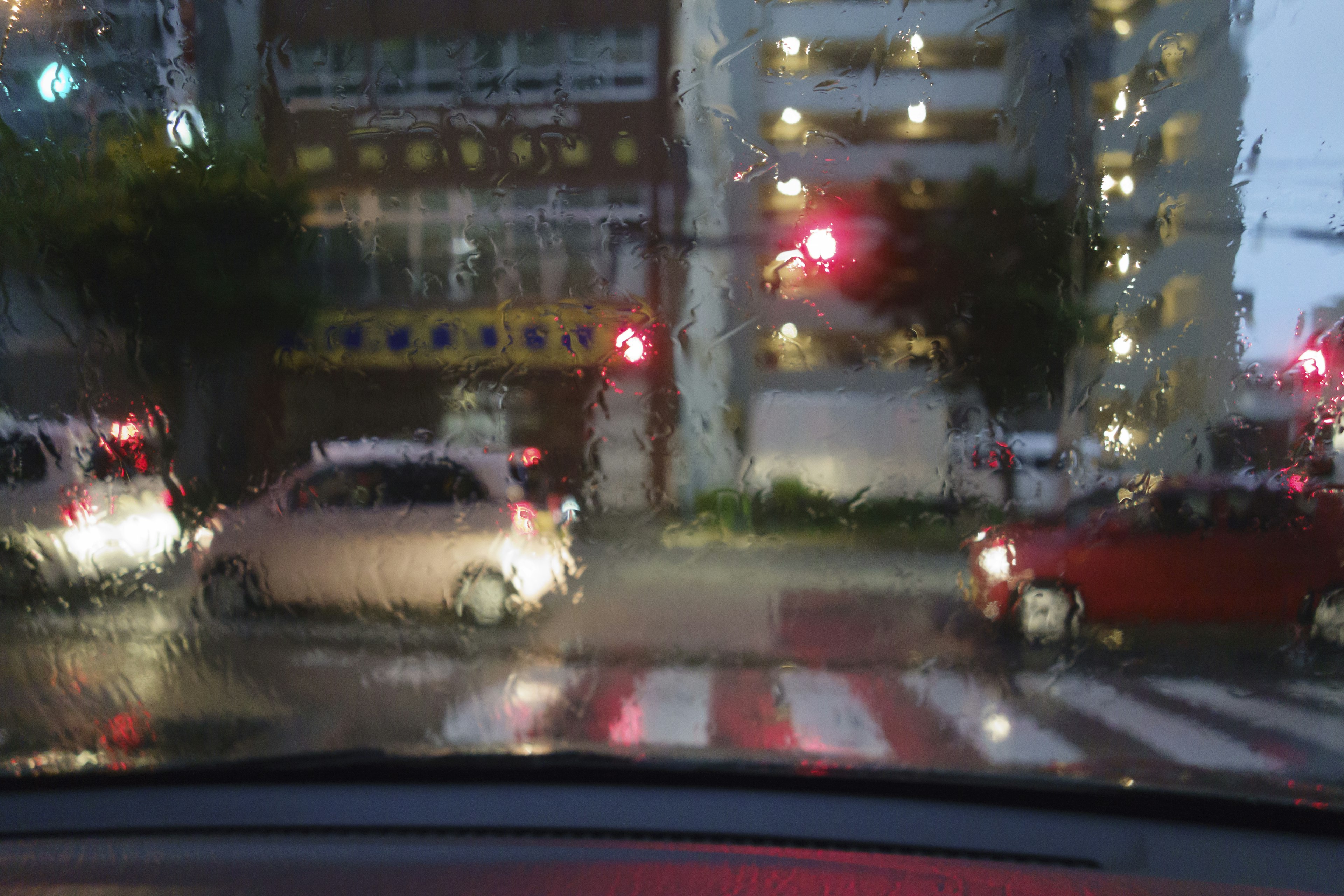 Intersection with cars waiting at a red light in the rain