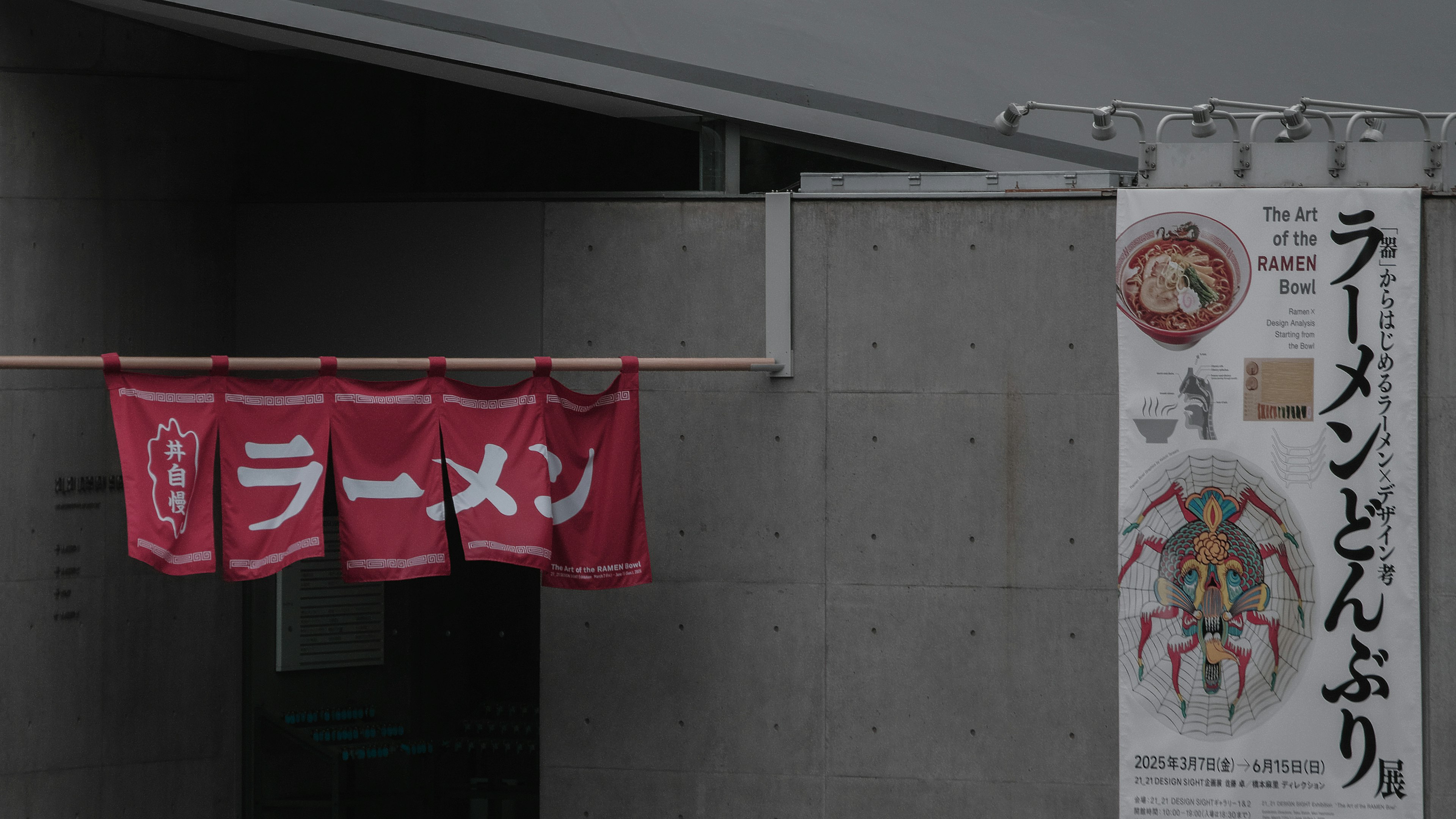 Entrée d'un restaurant de ramen avec des rideaux rouges affichant le mot 'ramen'