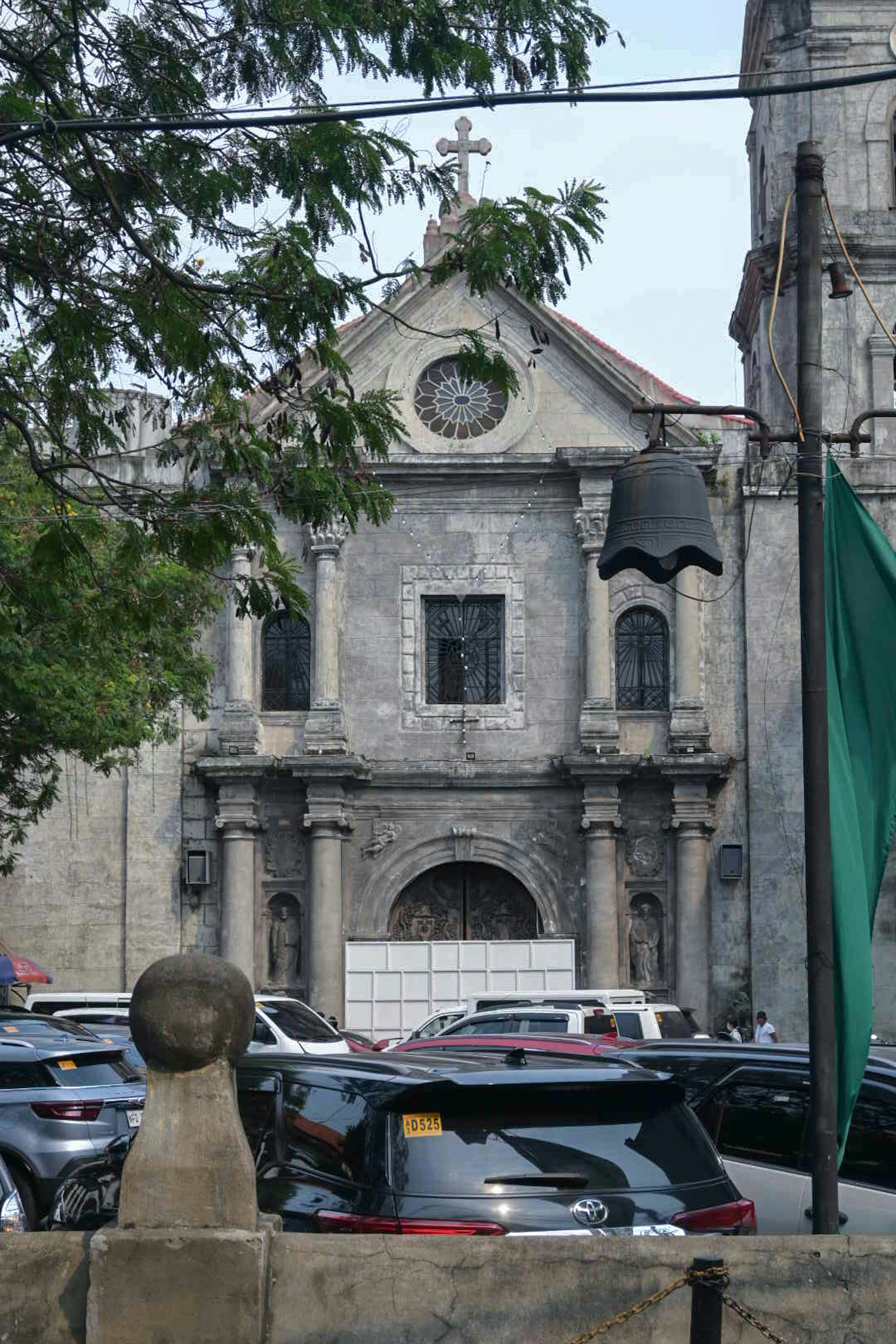 Fachada de una iglesia antigua con vehículos alrededor