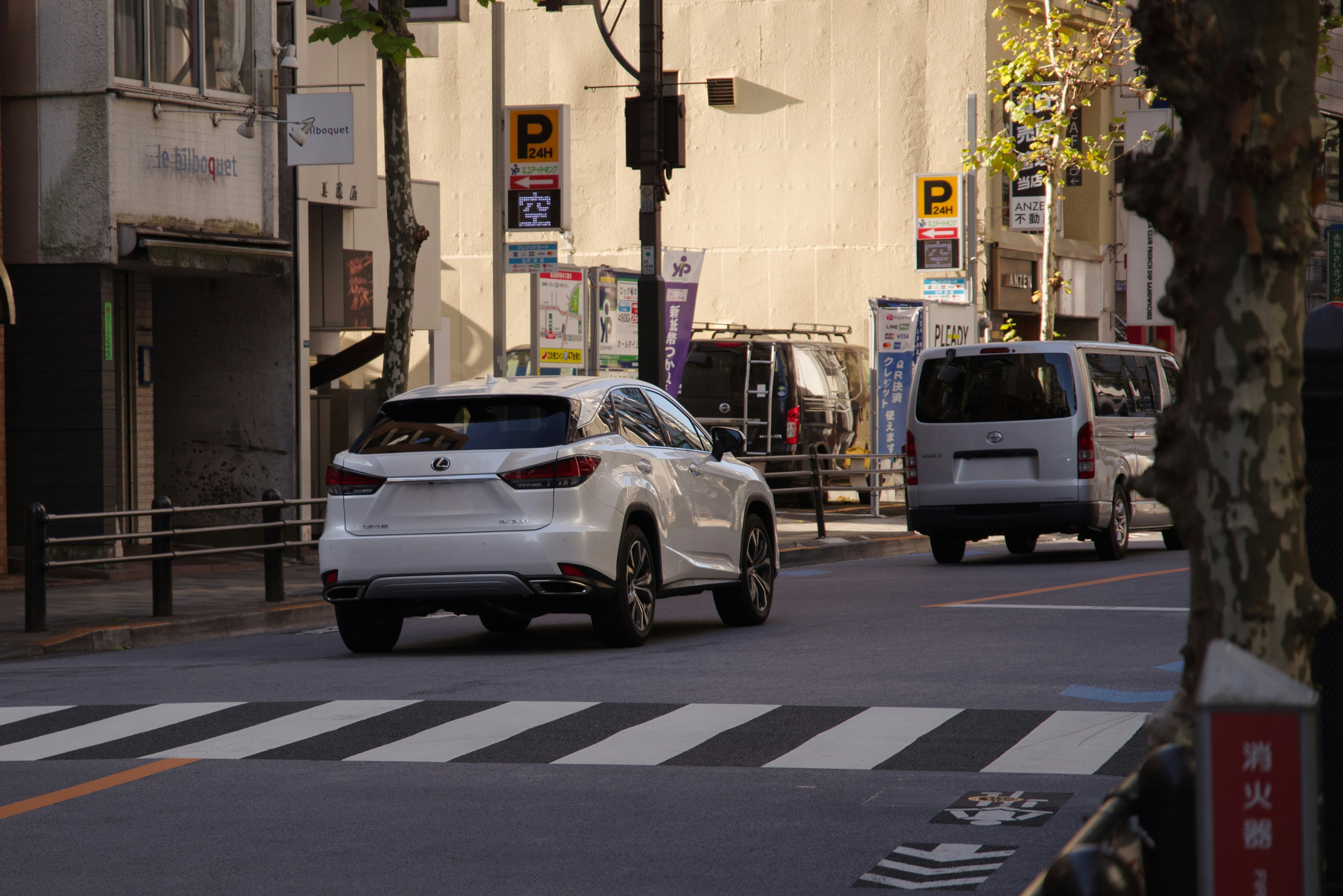 White SUV crossing a pedestrian crosswalk in an urban setting