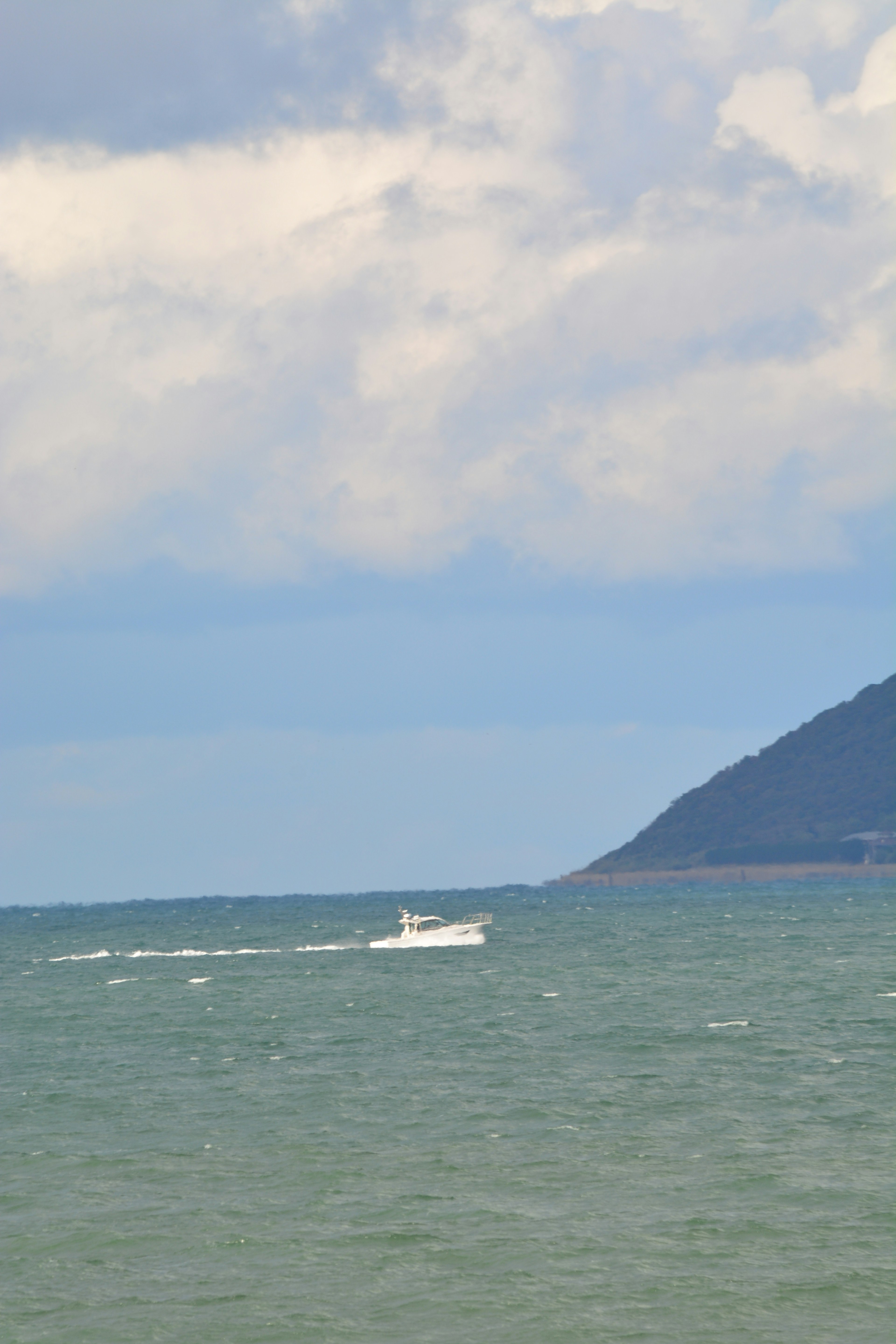 Un bateau se déplaçant sur la mer avec un arrière-plan montagneux