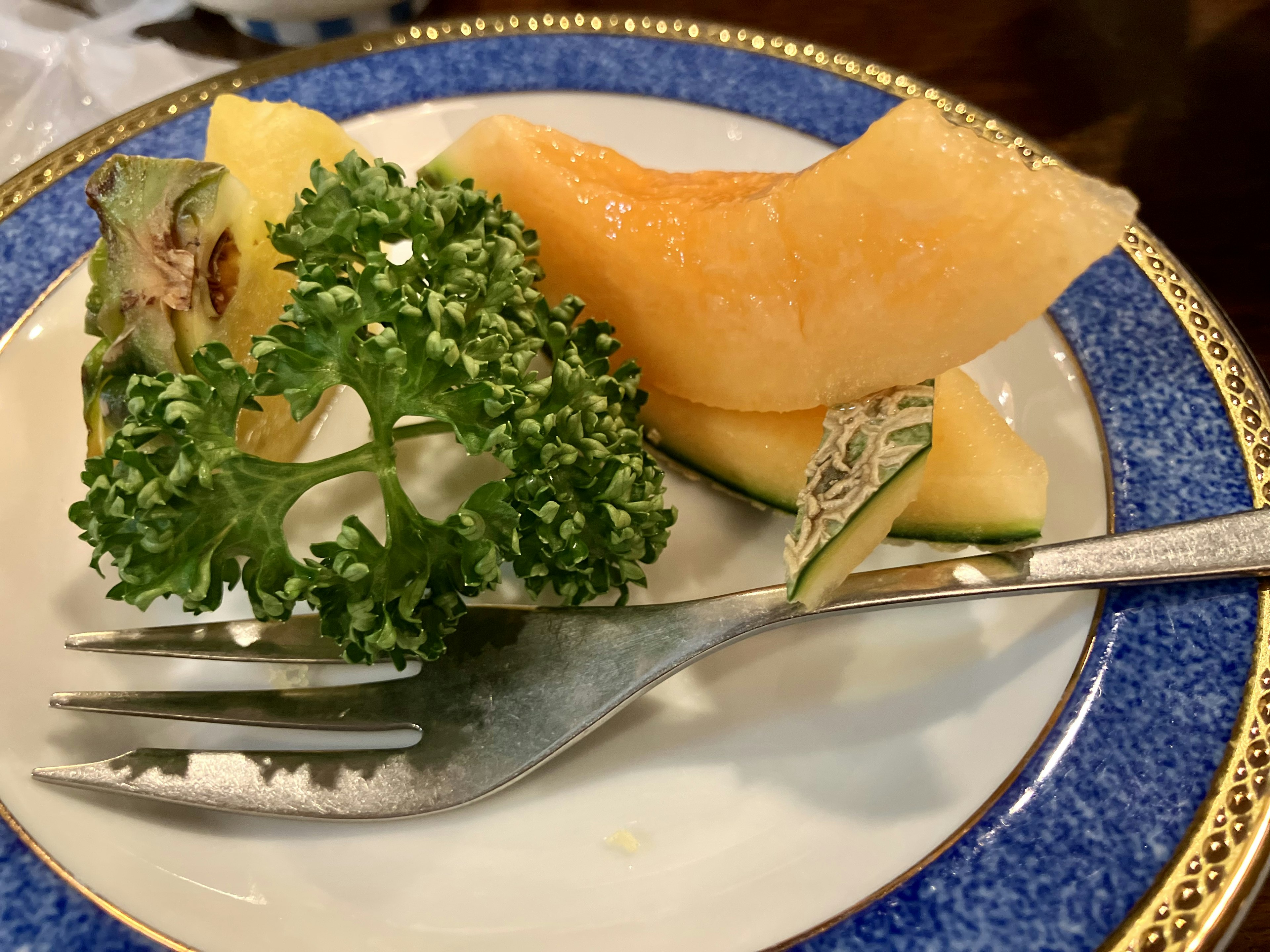 Une assiette joliment dressée avec du melon et du persil