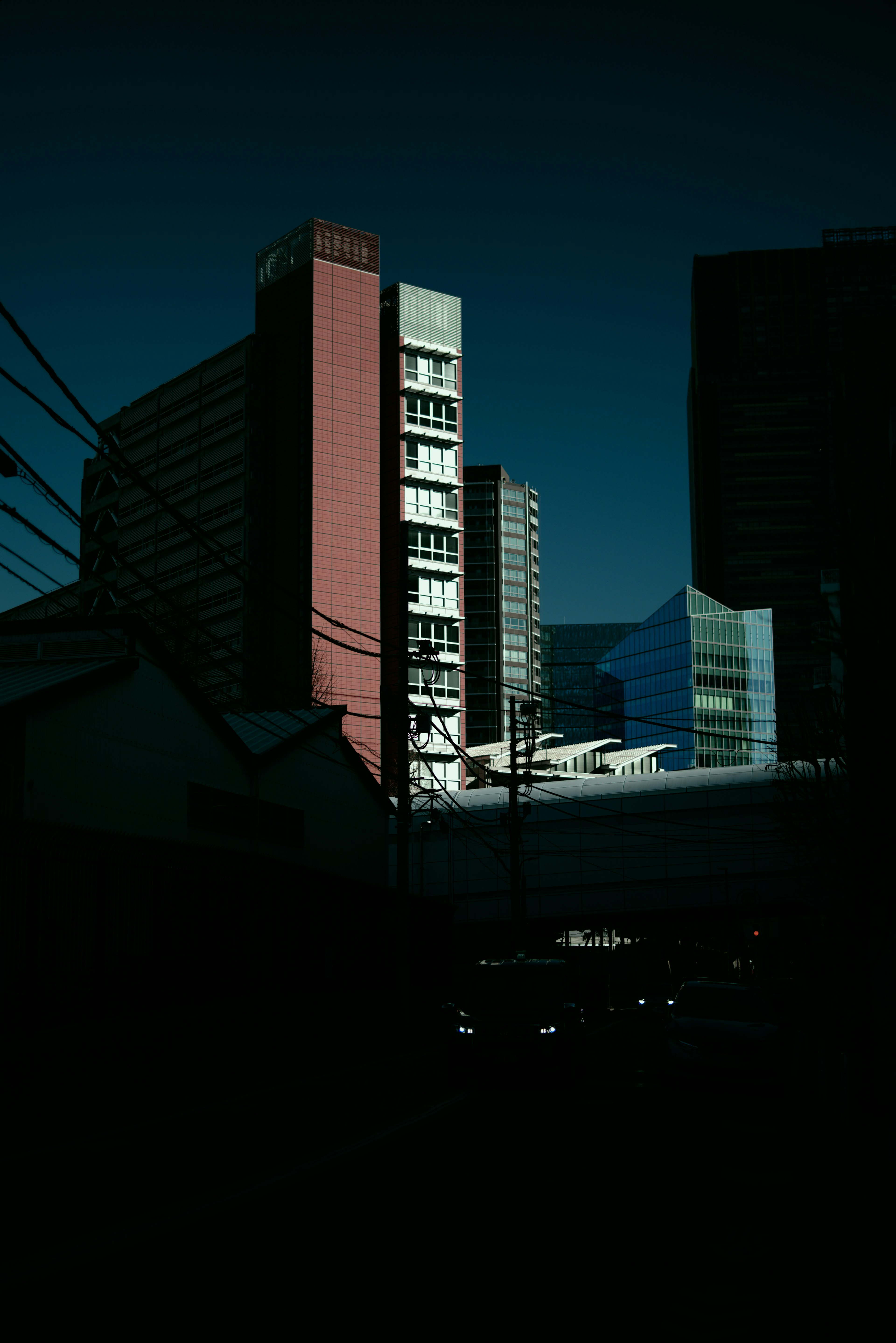 暗い背景に高層ビルが立ち並ぶ都市風景