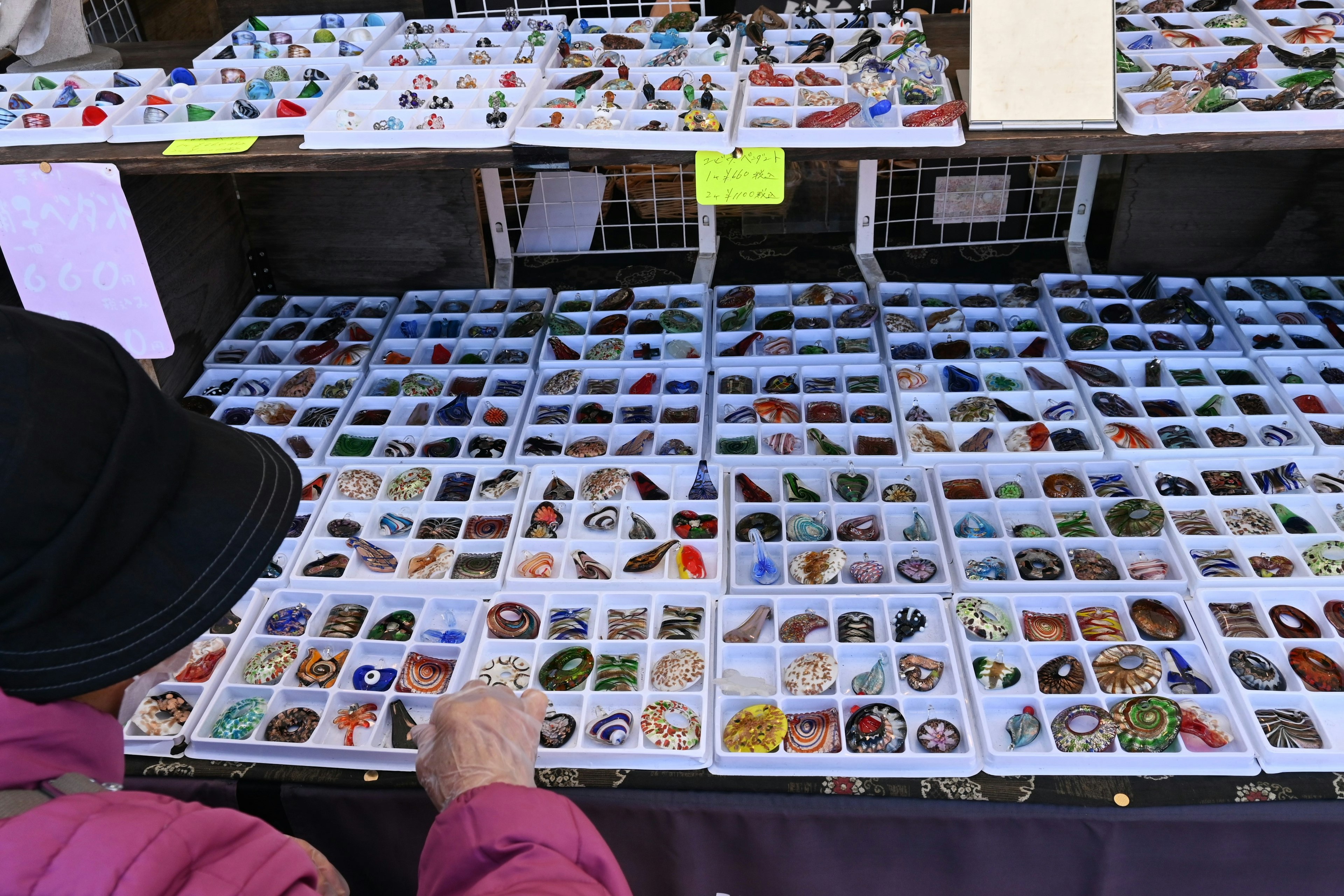 A person examining various stones and gems at a market stall