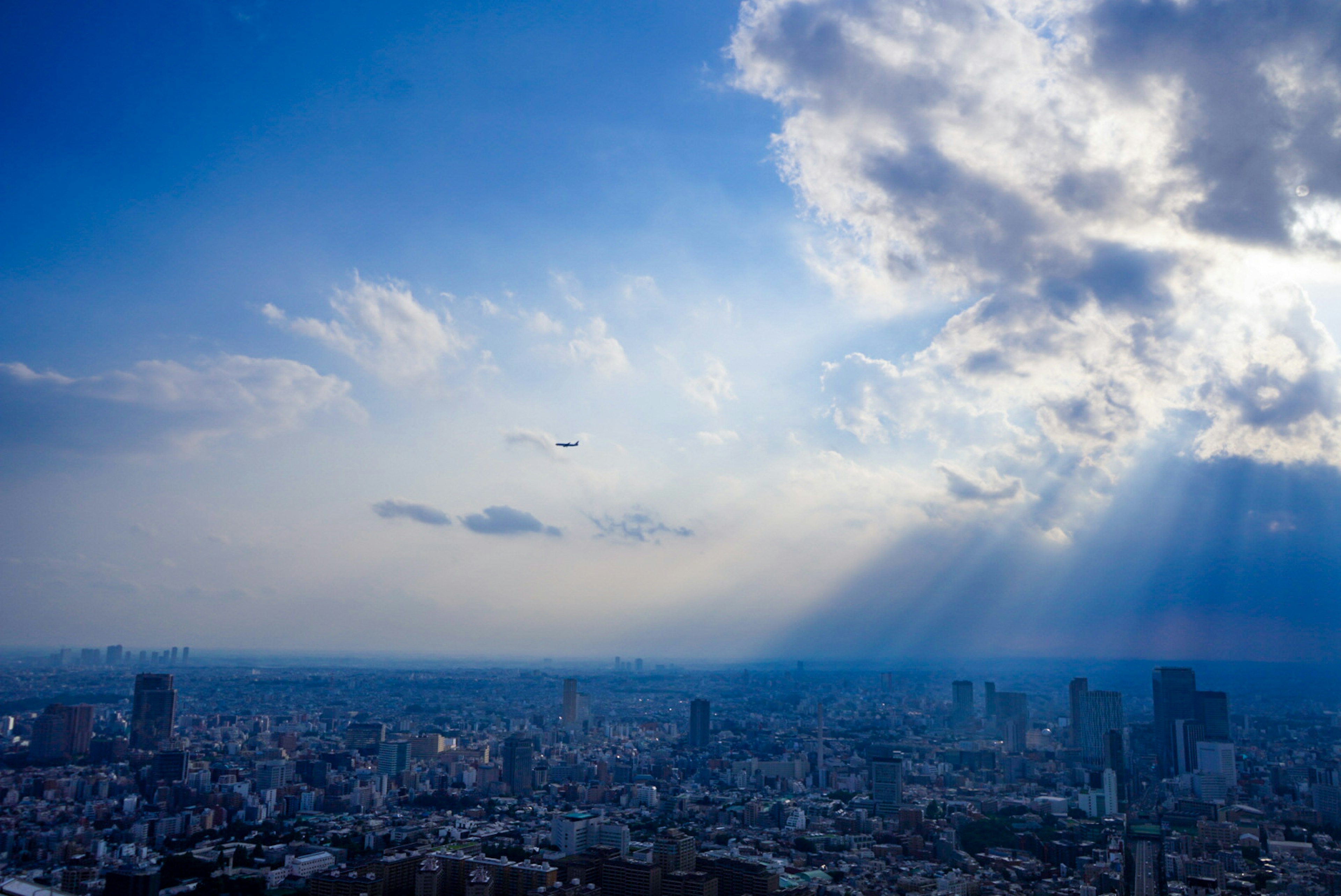 青空と雲の下に広がる都市景観の風景