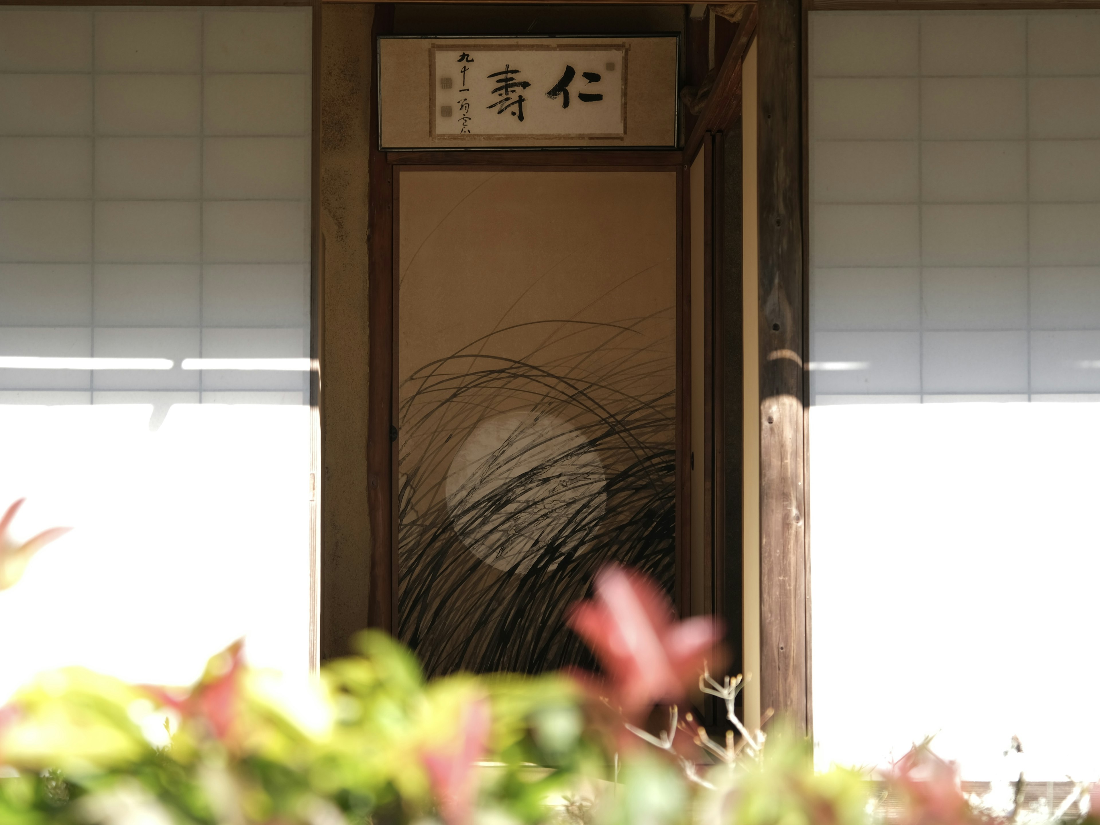 Entrée d'un bâtiment traditionnel japonais avec une porte en bois et des écrans shoji