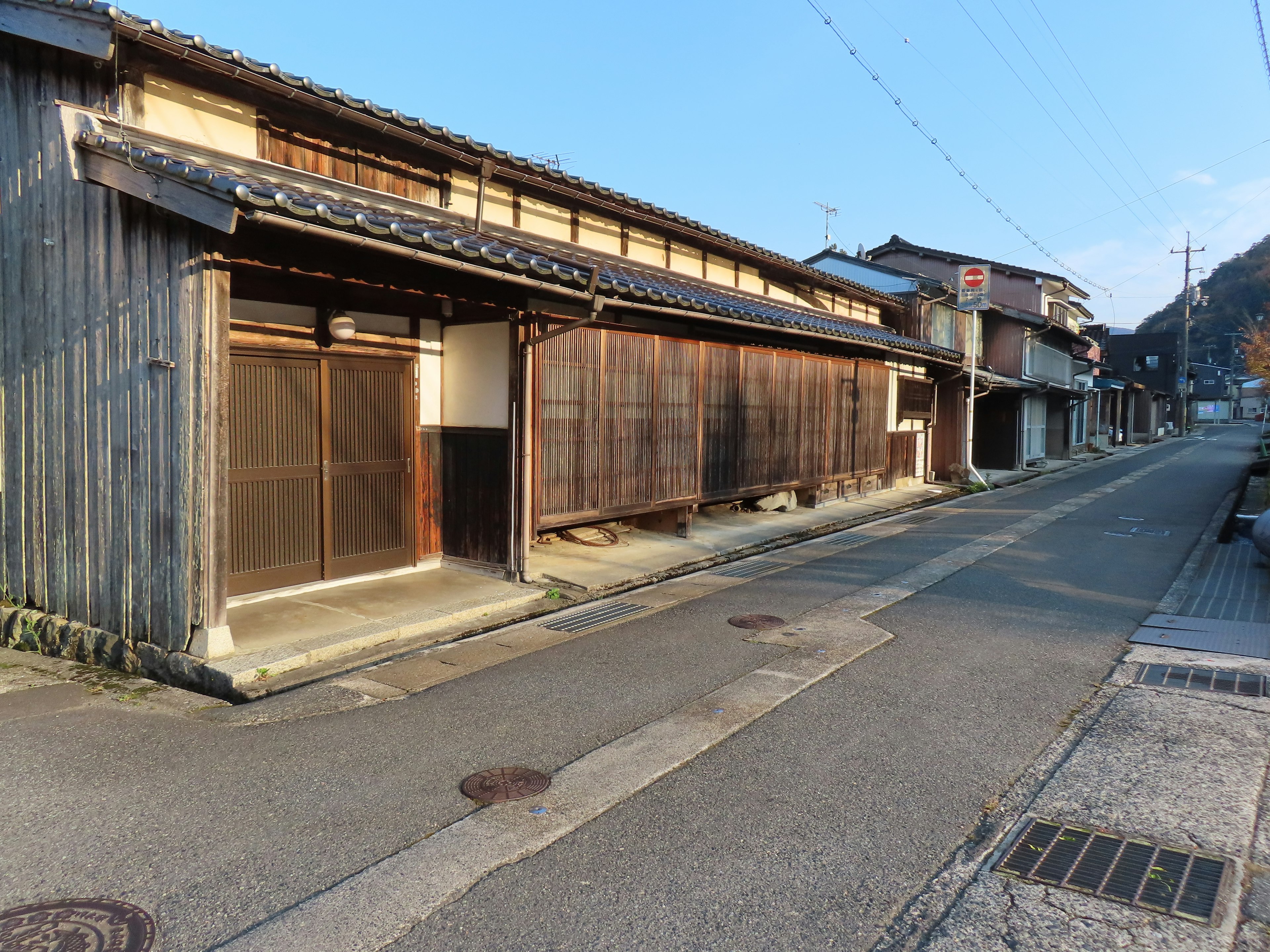 Calle japonesa tranquila con casas de madera tradicionales y camino pavimentado