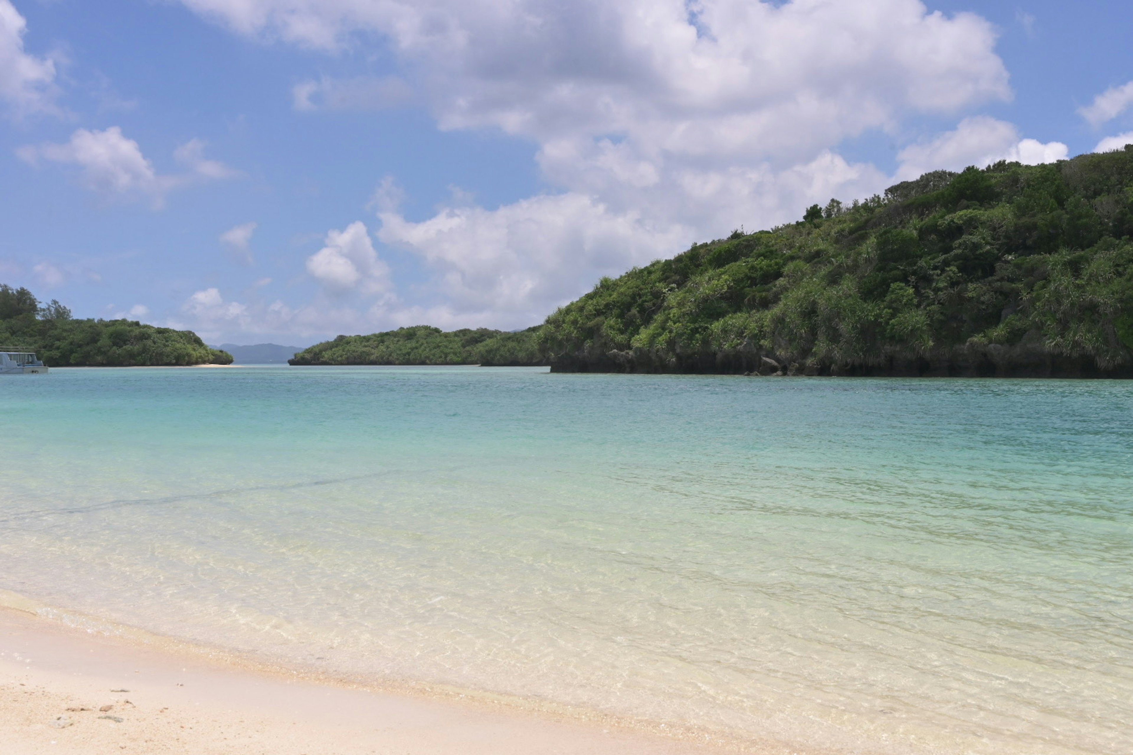 ทิวทัศน์ชายหาดที่สวยงามพร้อมน้ำทะเลสีฟ้าใสและทรายขาว