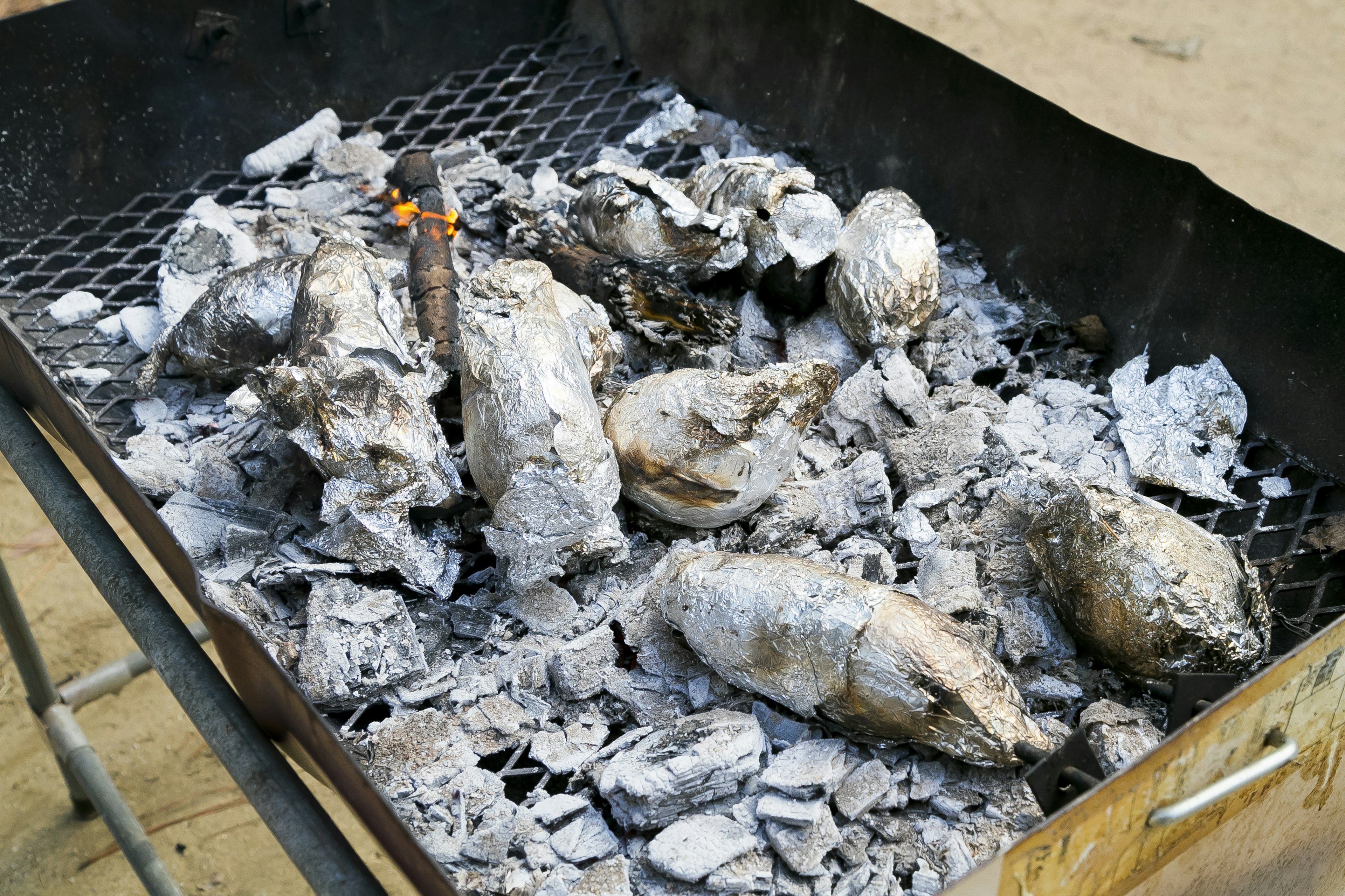 Grill dengan cangkang yang hangus dan abu dari makanan laut