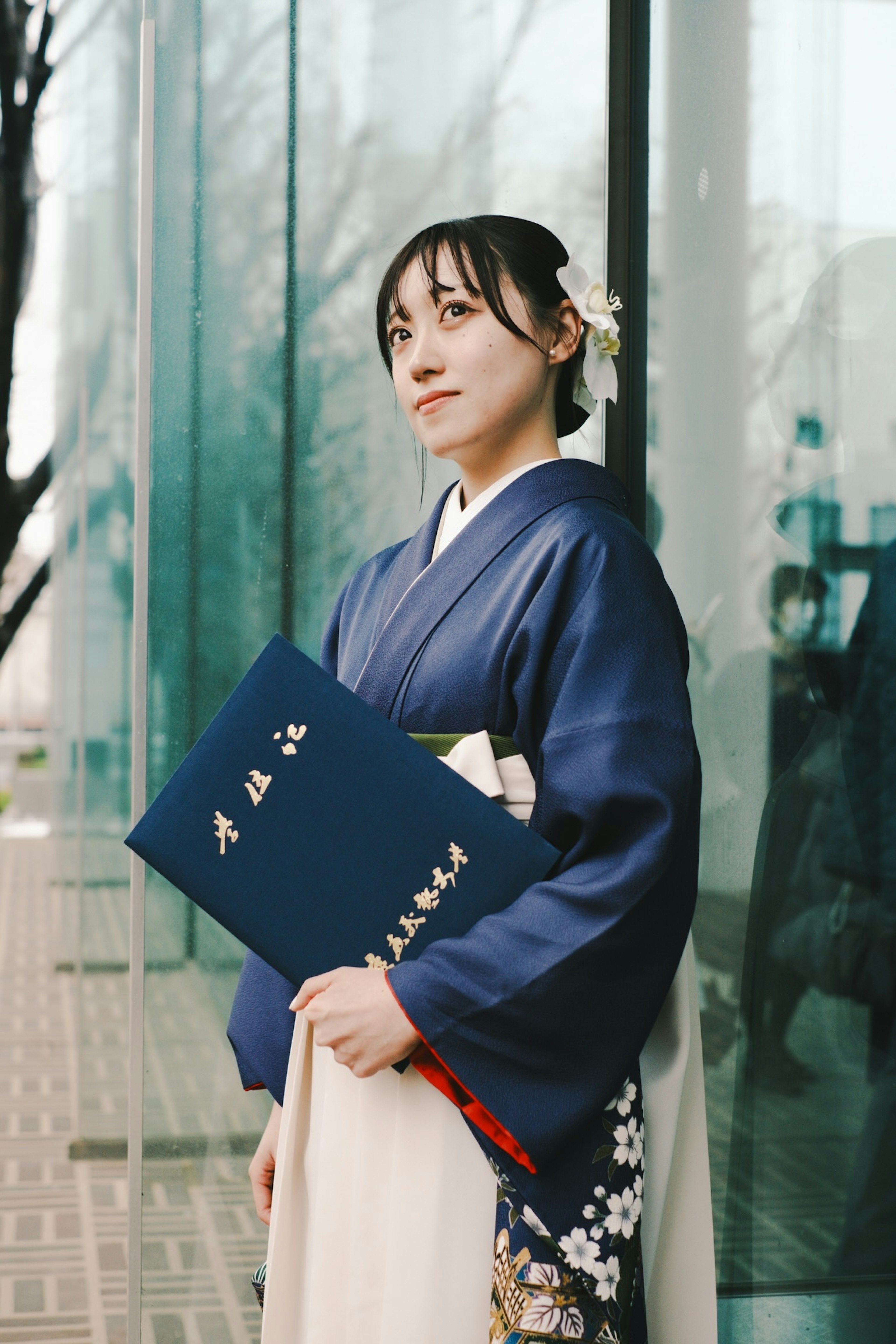 Femme en kimono traditionnel tenant un dossier bleu