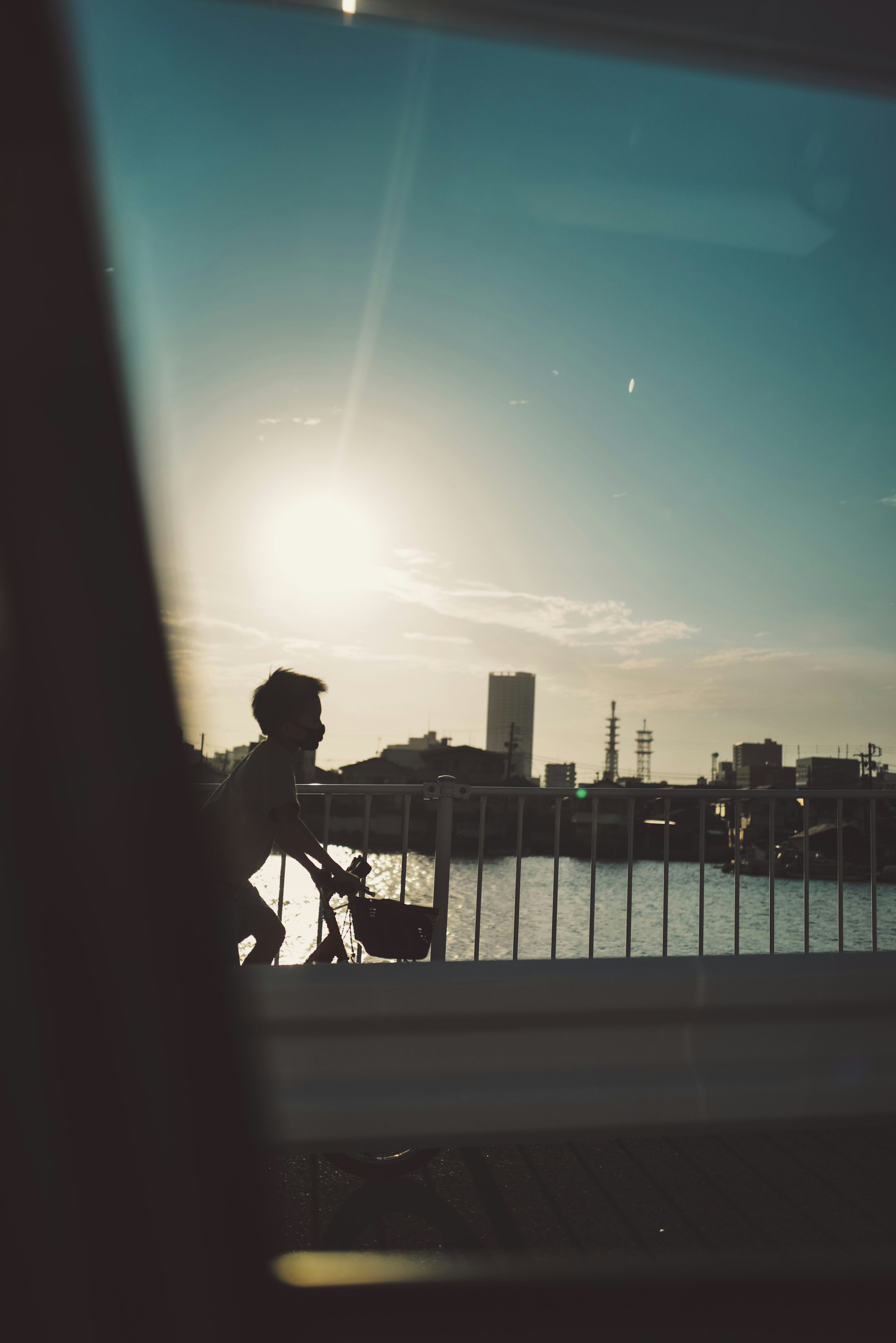 Silhouette einer Person, die gegen einen Sonnenuntergang radelt