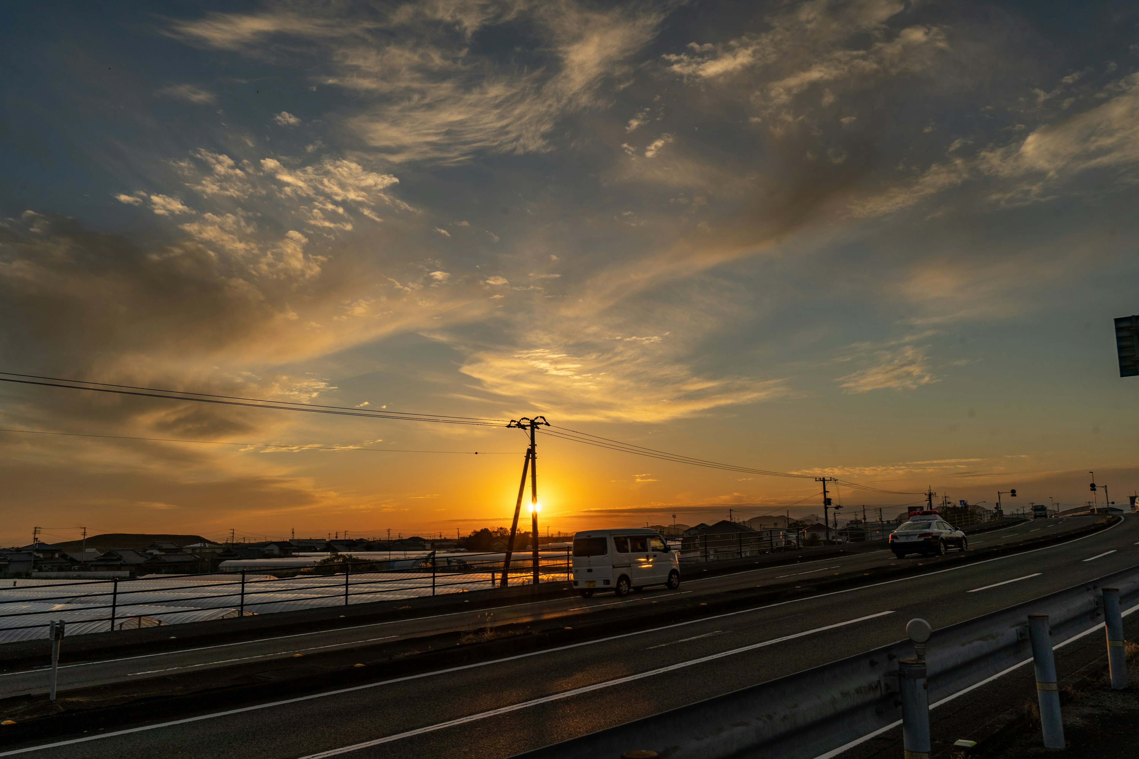 夕日が沈む風景と道路が広がる夕暮れの空