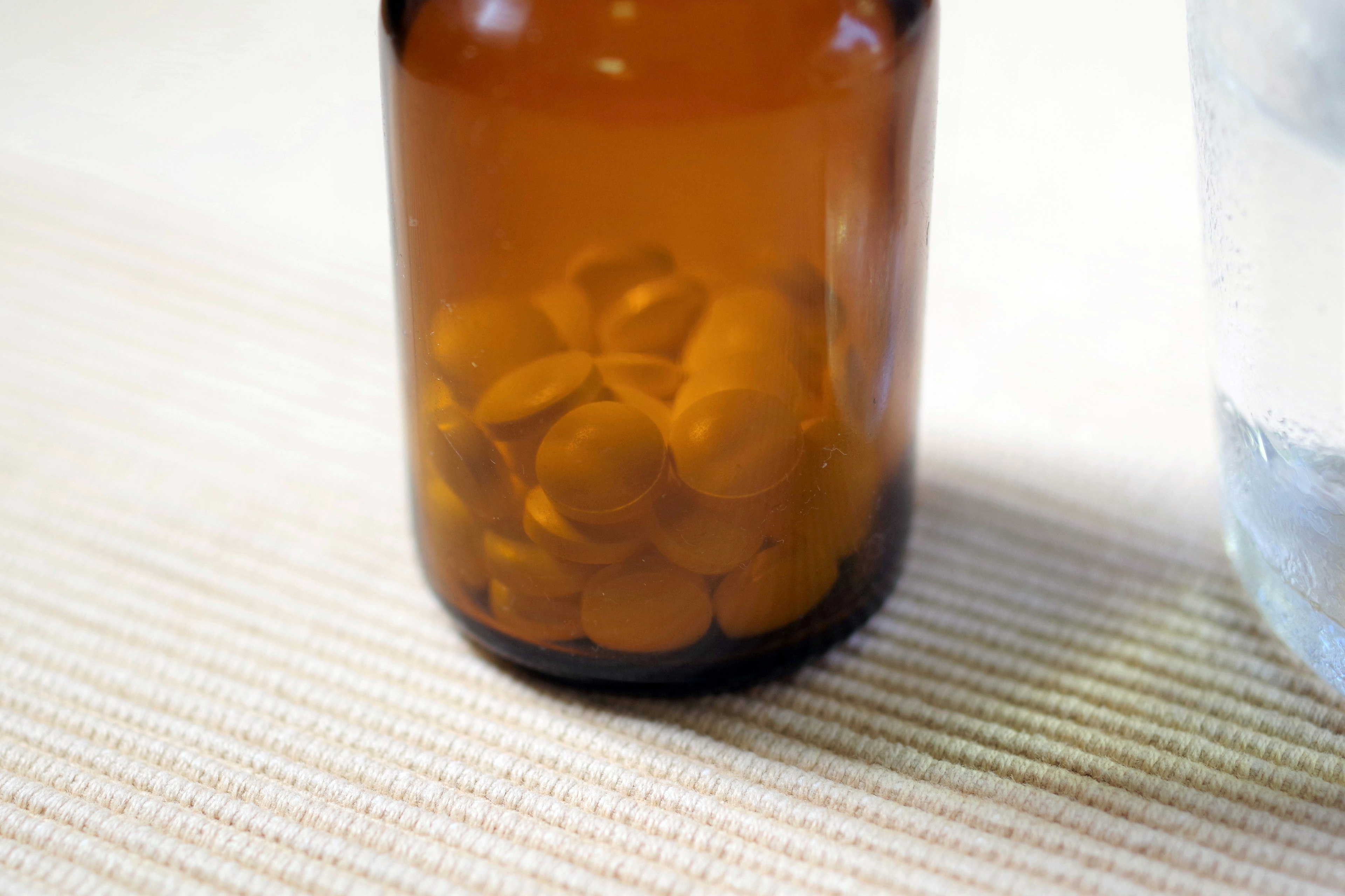 Brown bottle containing orange round pills