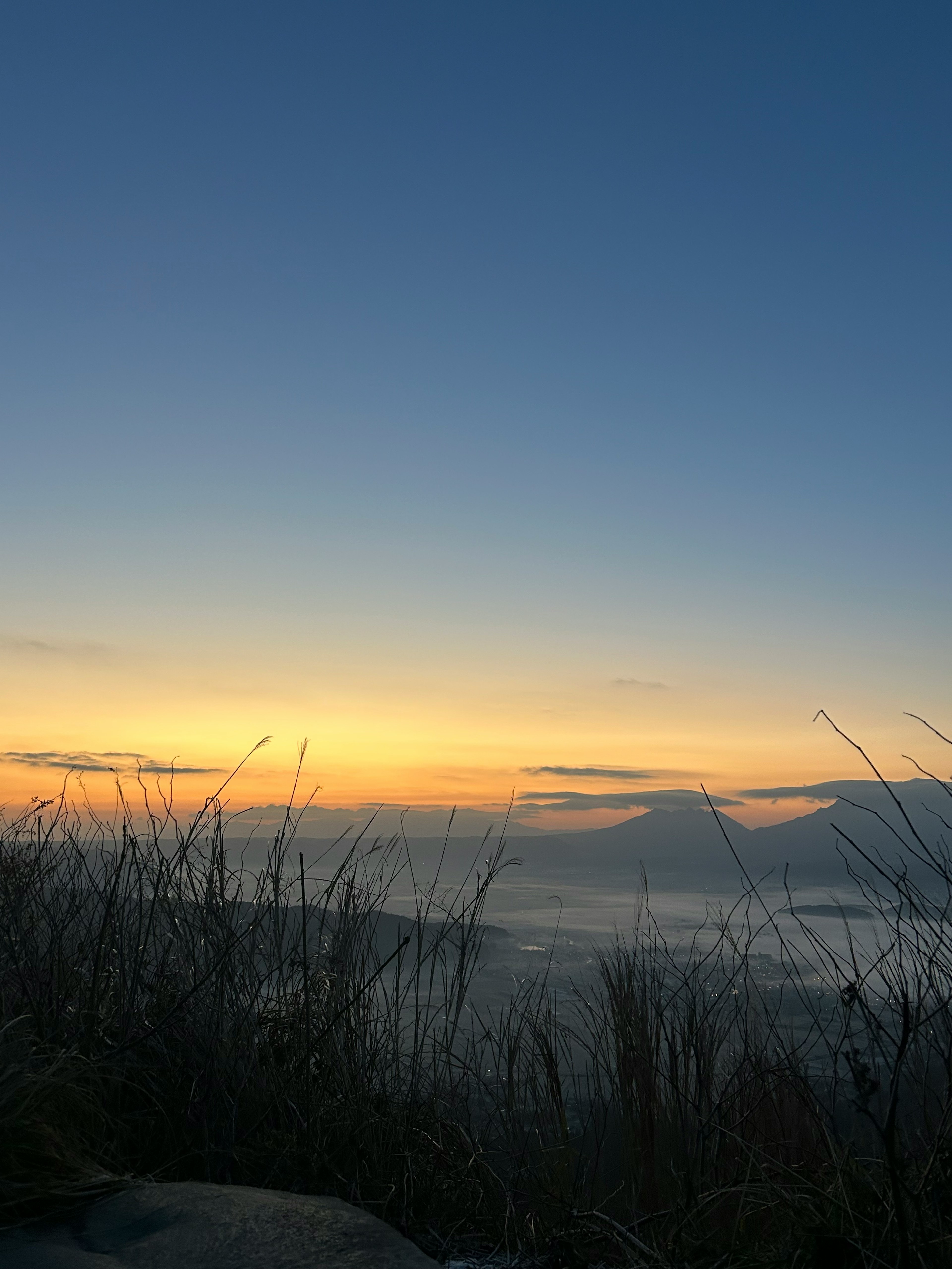 Eine ruhige Landschaft mit Bergen und einem bunten Sonnenaufgangshimmel