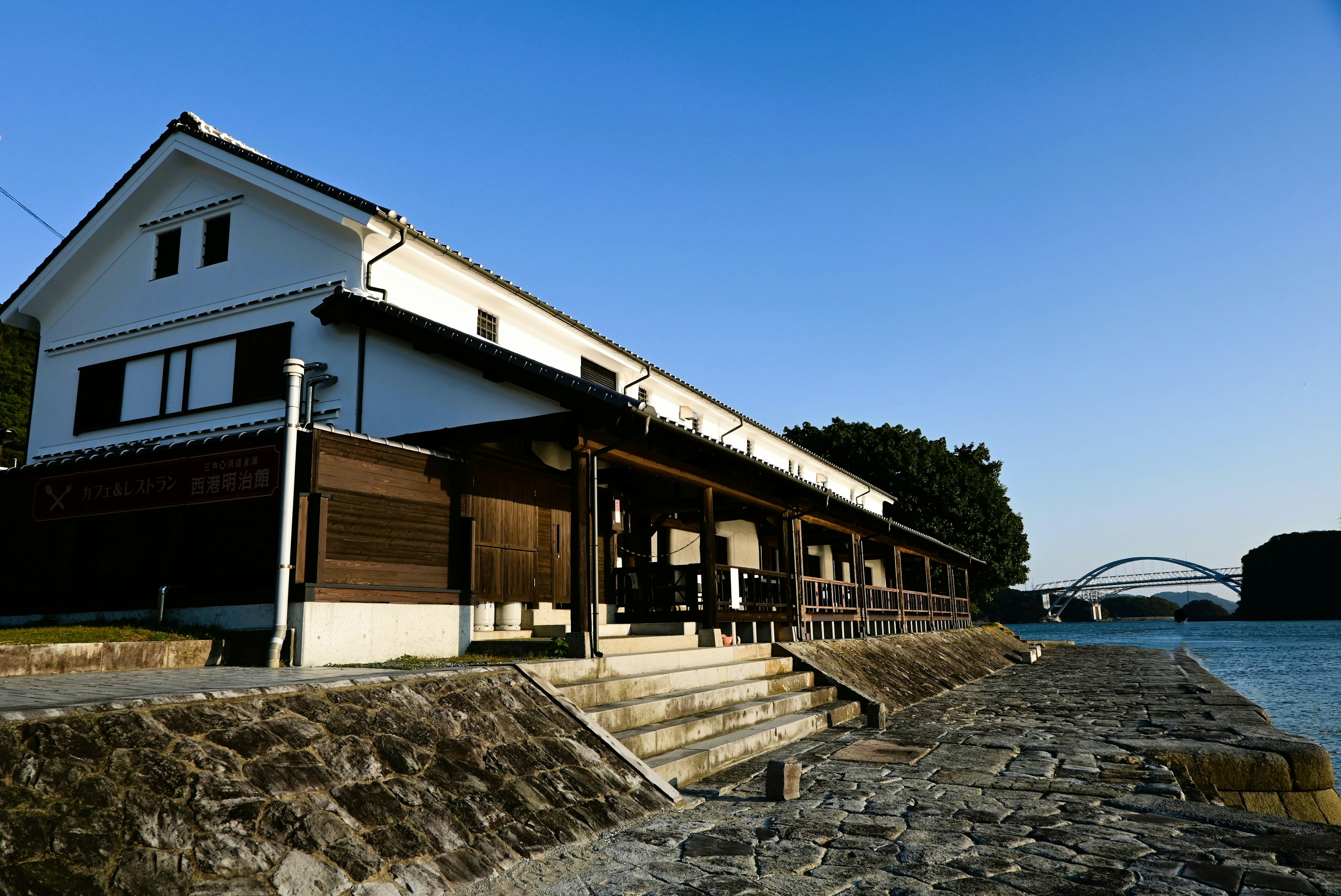 川の近くにある白い家屋と石の堤防の風景