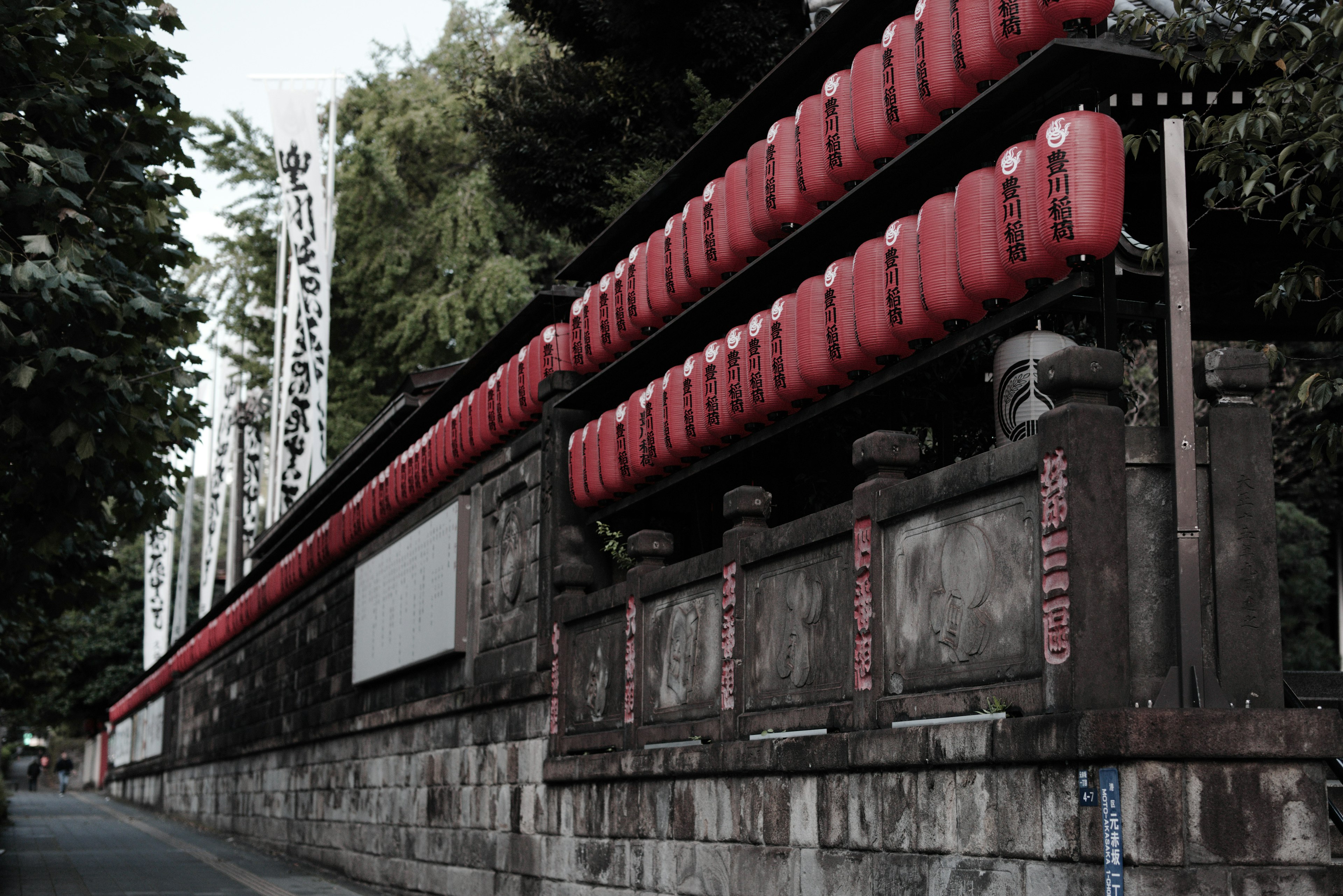 Scenic view of red lanterns lined along an old stone wall