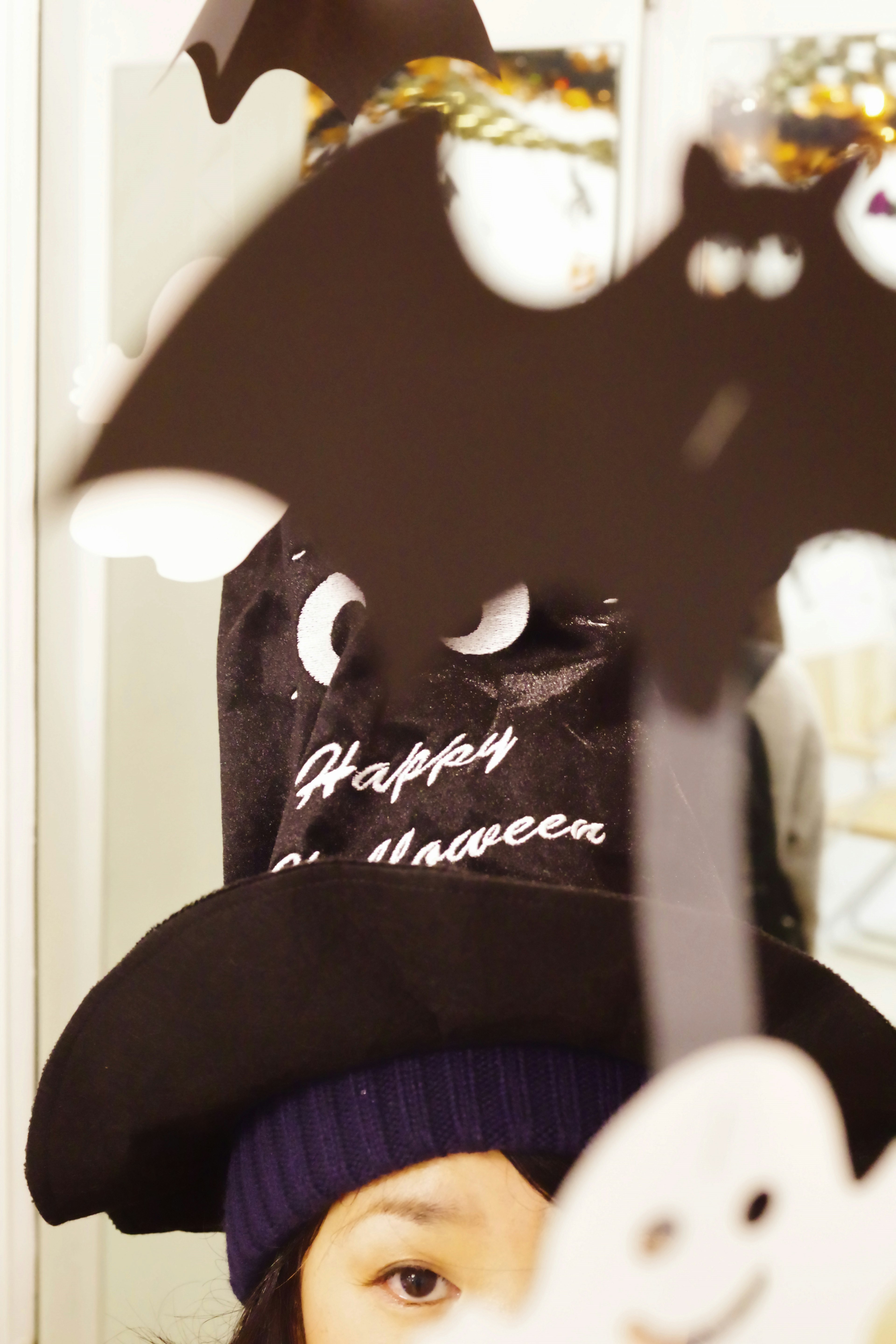 Child wearing a Halloween hat with black bat decorations