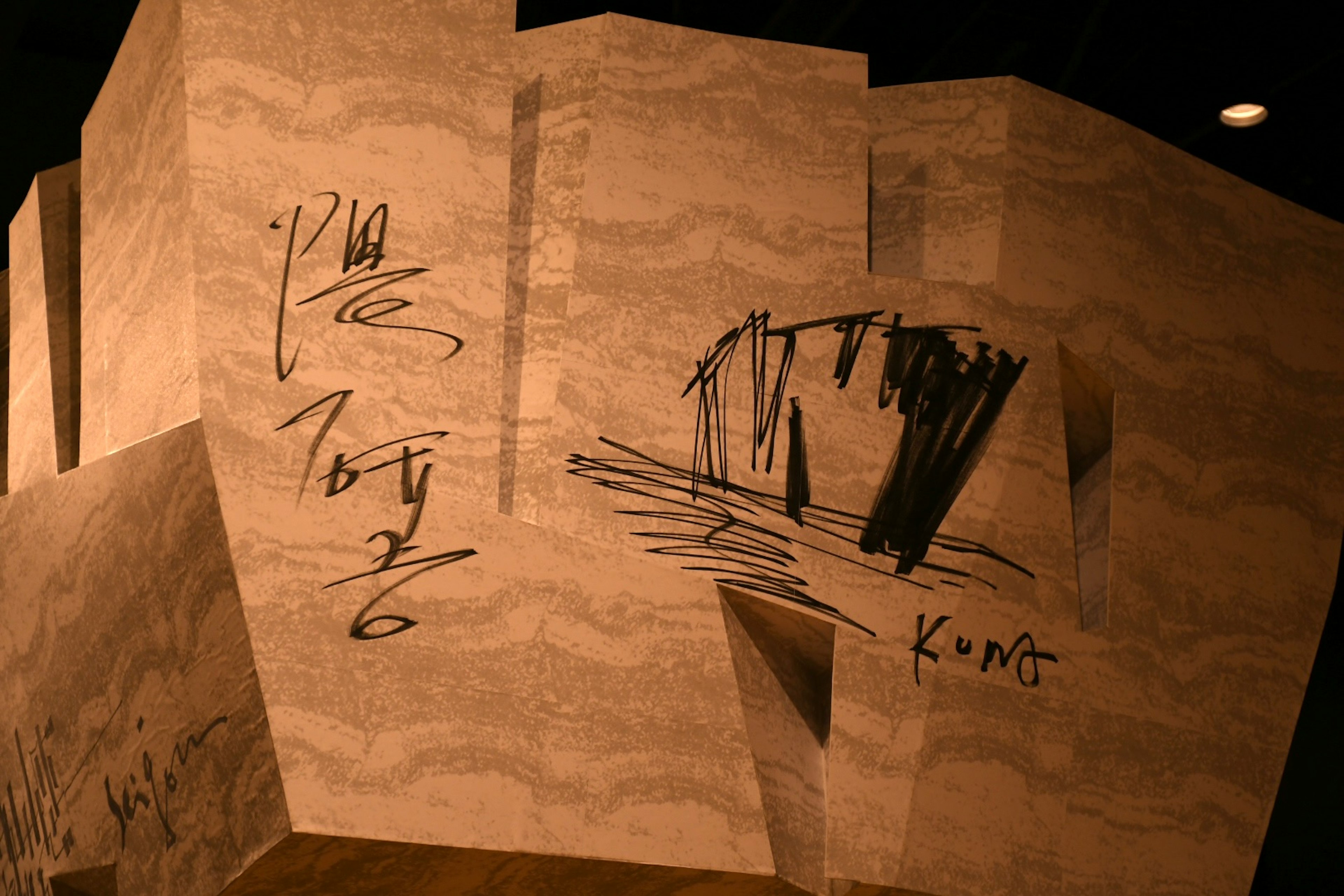 Abstract sculpture surface featuring black line drawings and inscriptions